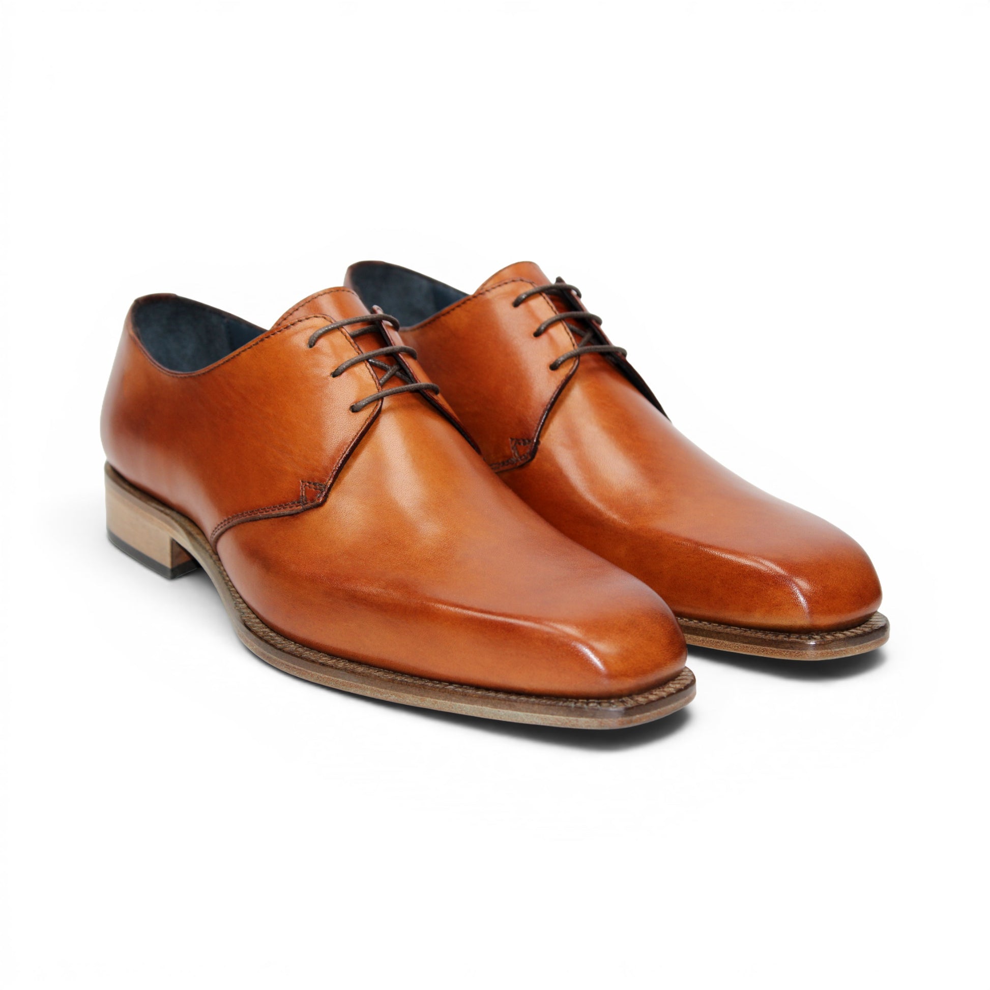 The Duca Sermoneta Cognac by Duca Di Matiste, a classic brown Italian leather dress shoe with a low wooden heel and black lining, is shown in a side view against a white background, highlighting its timeless elegance.