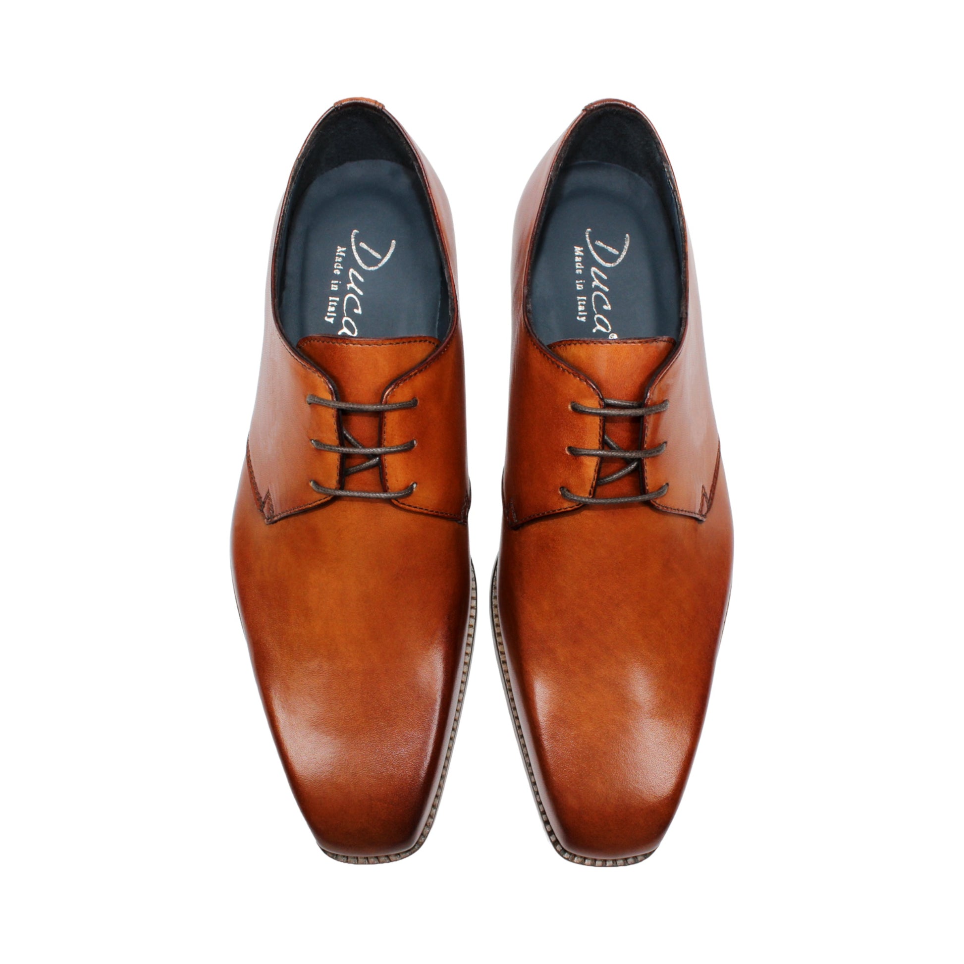 The Duca Sermoneta Cognac by Duca Di Matiste, a classic brown Italian leather dress shoe with a low wooden heel and black lining, is shown in a side view against a white background, highlighting its timeless elegance.