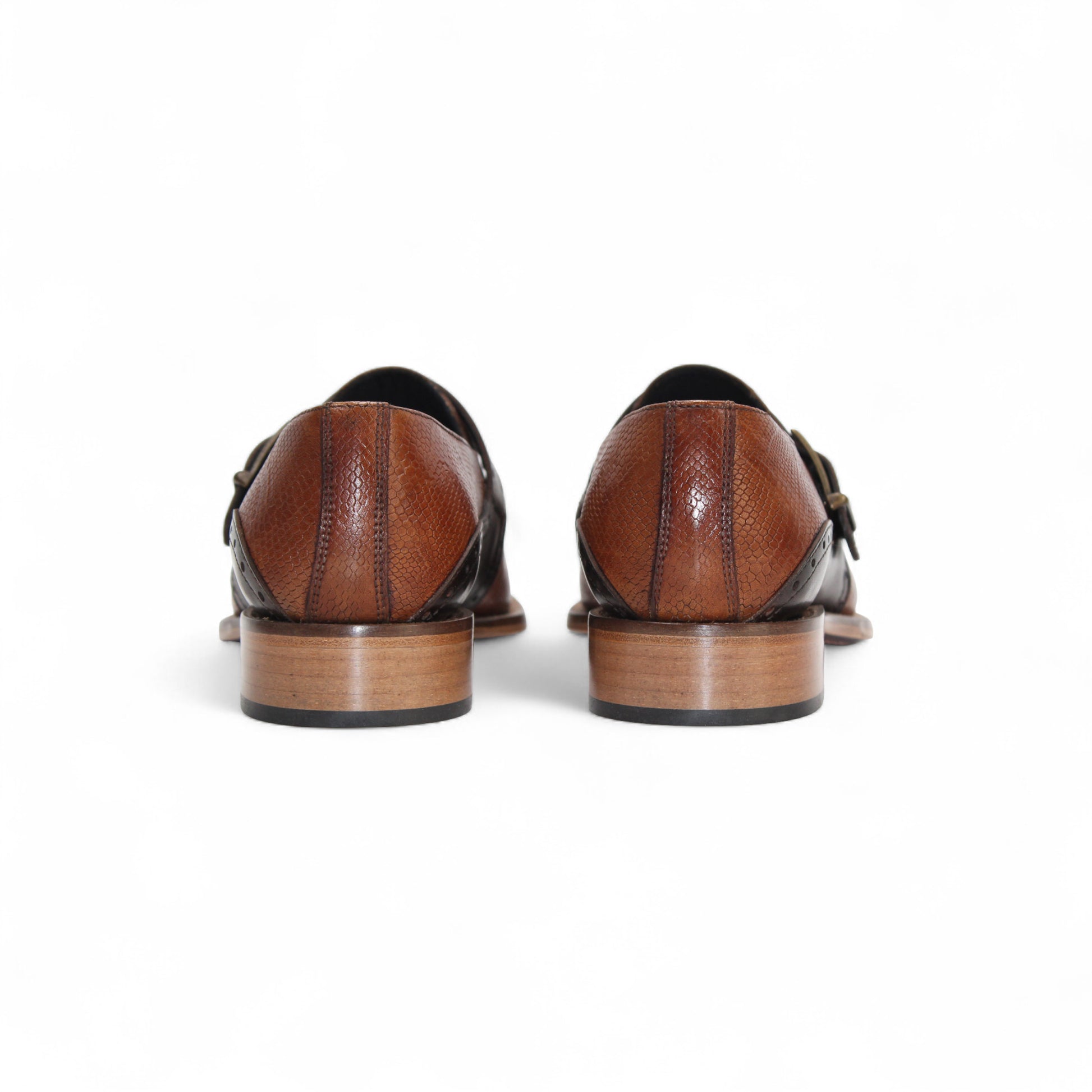 The Duca Sezze Cognac/Chocolate by Duca Di Matiste is a luxurious brown leather dress shoe with a black strap, buckle, and low wooden heel, reflecting Italian craftsmanship in a stylish side profile on a white background.