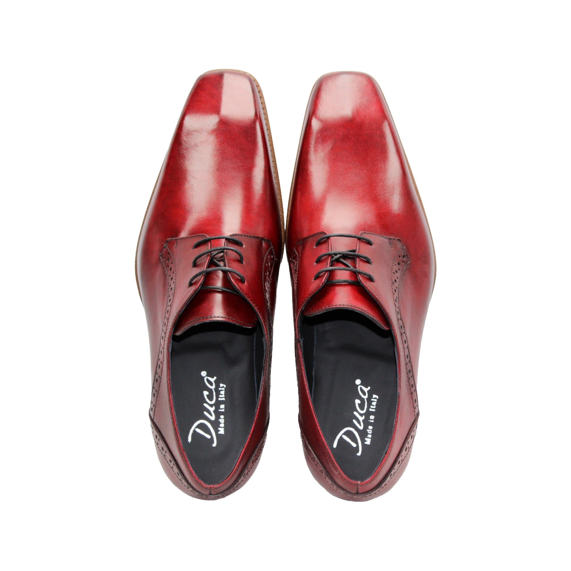 The Duca Di Matiste Duca Spada Antique Red is an Italian leather dress shoe in red with brogue detailing, black laces, and a light brown wooden sole, shown in profile on a white background.