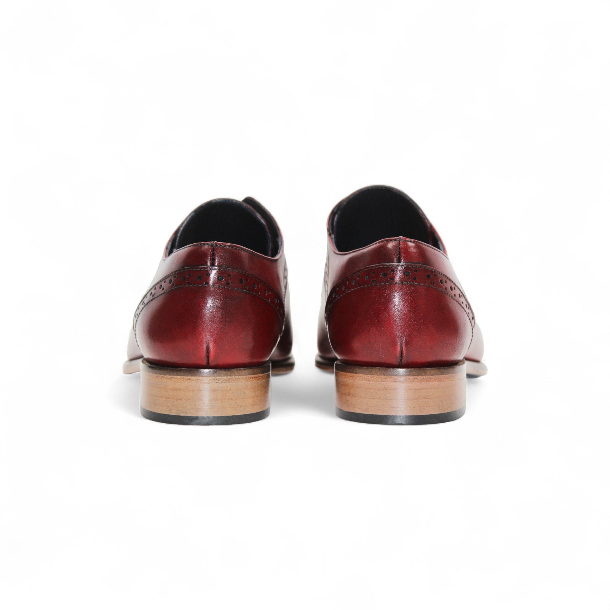 The Duca Di Matiste Duca Spada Antique Red is an Italian leather dress shoe in red with brogue detailing, black laces, and a light brown wooden sole, shown in profile on a white background.