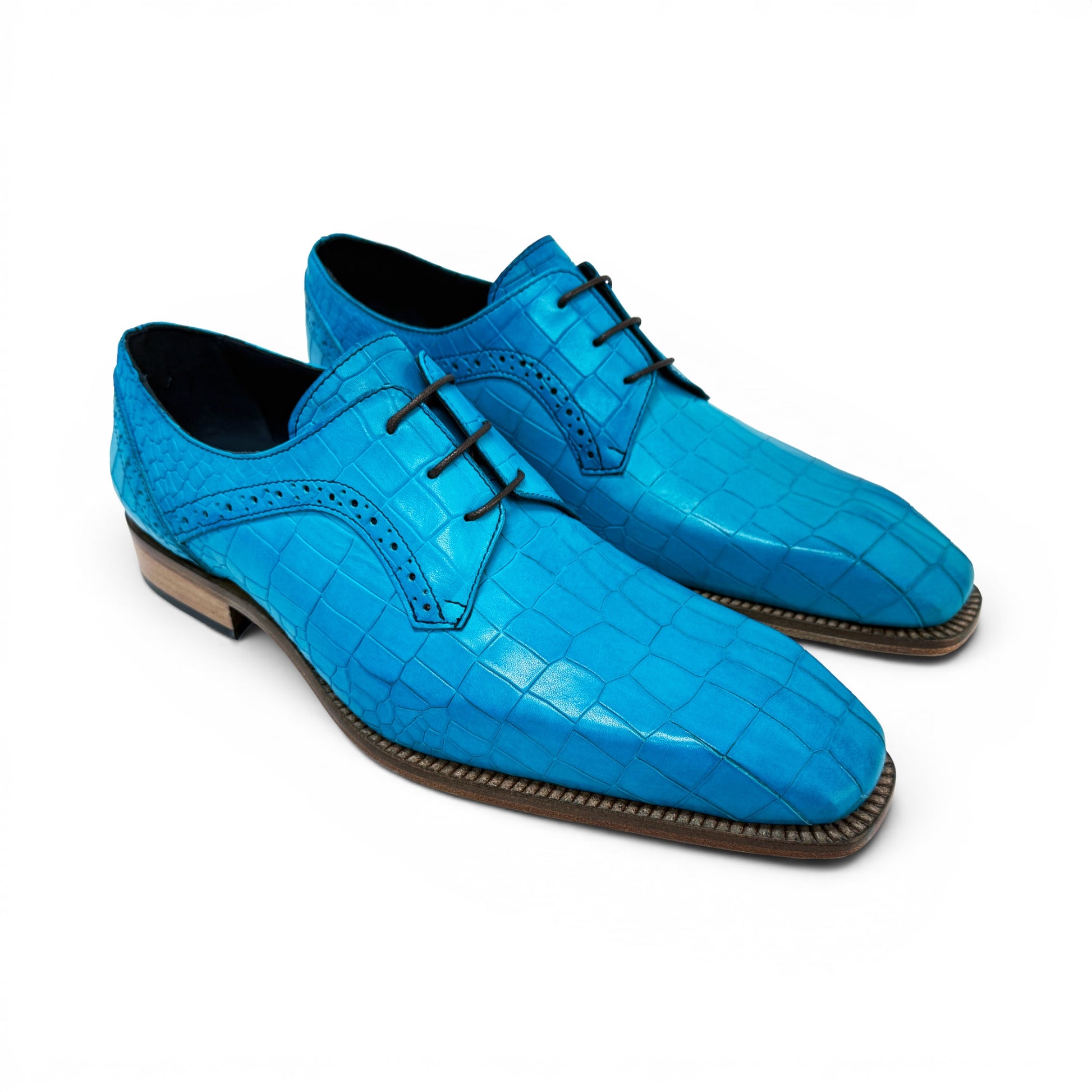 The Duca Di Matiste Duca Spada Turquoise is an Italian-made turquoise leather shoe with a crocodile pattern, black laces, and a light brown sole, shown in side profile against a white background.