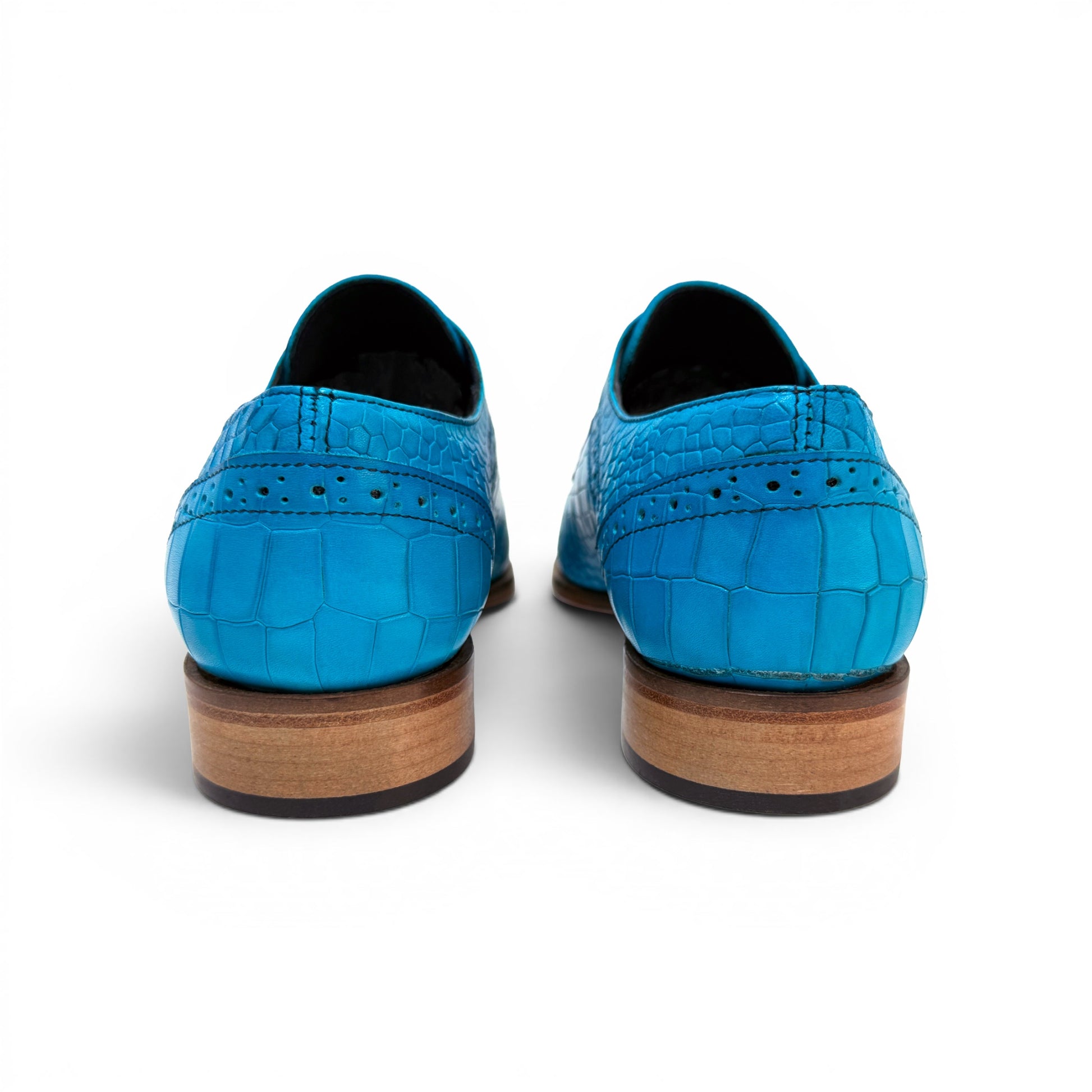 The Duca Di Matiste Duca Spada Turquoise is an Italian-made turquoise leather shoe with a crocodile pattern, black laces, and a light brown sole, shown in side profile against a white background.
