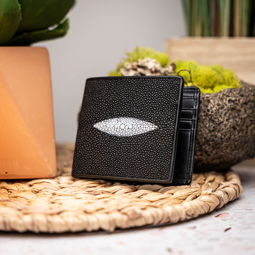 The Marco Di Milano Vallo Wallet Black is a textured luxury men's wallet with a central oval reflective accent, shown partially open on a white background.