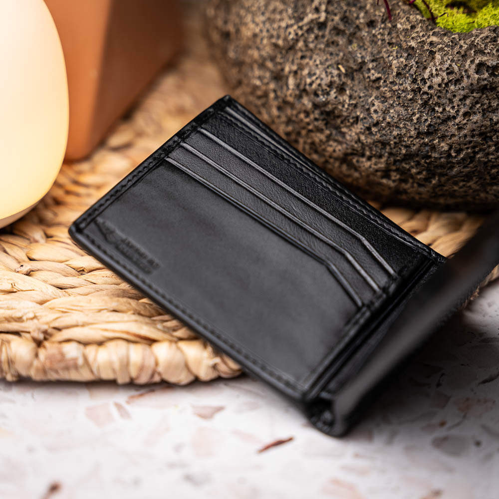 The Marco Di Milano Vallo Wallet Black is a textured luxury men's wallet with a central oval reflective accent, shown partially open on a white background.
