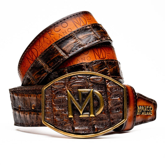 The Texas Belt Aged Brown by Marco Di Milano features embossed brown leather, a brass "MD" logo buckle, inner branding, and design details inspired by the elegance of a caiman crocodile belt.