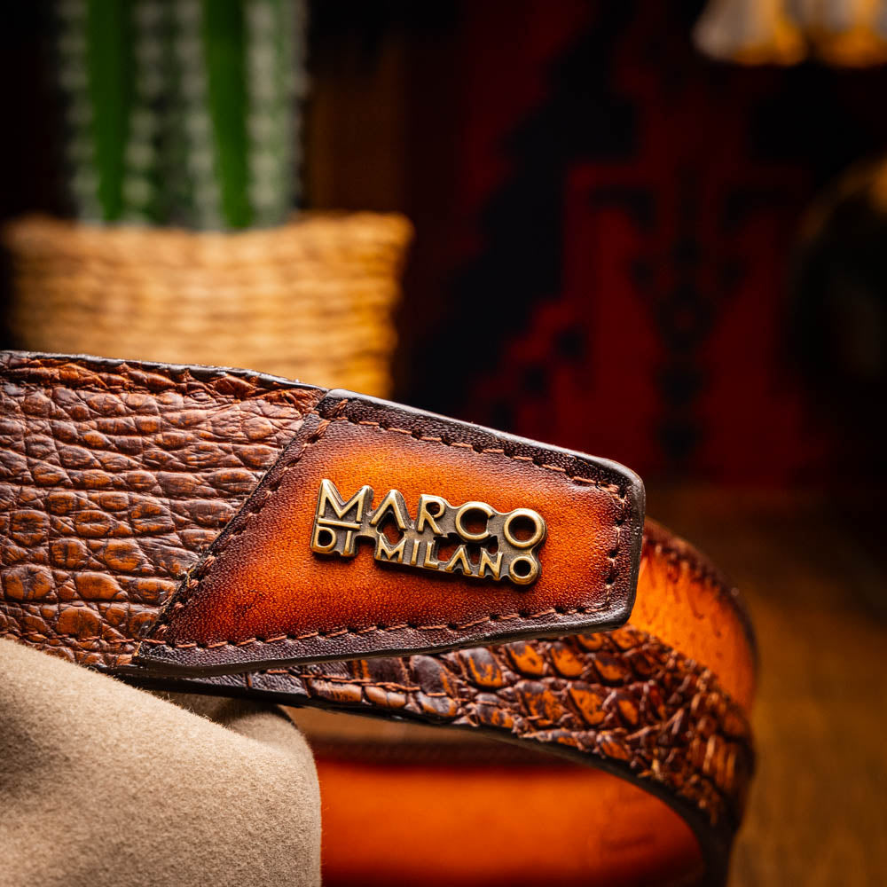 The Texas Belt Aged Maple by Marco Di Milano is crafted from luxurious caiman crocodile skin in a brown finish, featuring a large brass buckle engraved with "MD" and the brand name embossed on the leather.