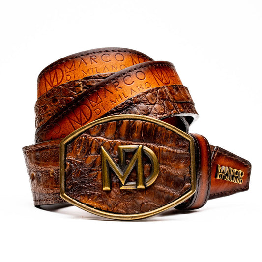 The Texas Belt Aged Maple by Marco Di Milano is crafted from luxurious caiman crocodile skin in a brown finish, featuring a large brass buckle engraved with "MD" and the brand name embossed on the leather.