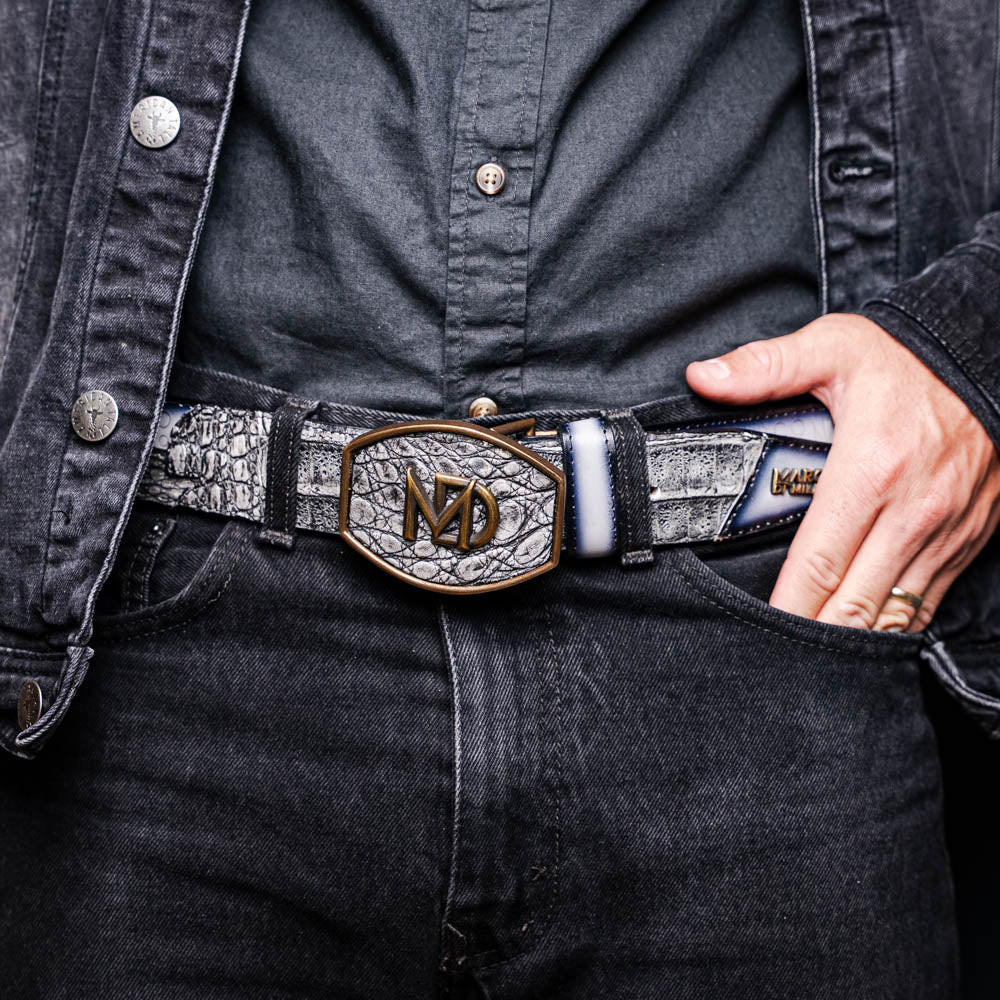 The Marco Di Milano Texas Belt Stone Gray features a textured gray finish, a large gold MD logo buckle, and "Marco Di Milano" printed along the strap.