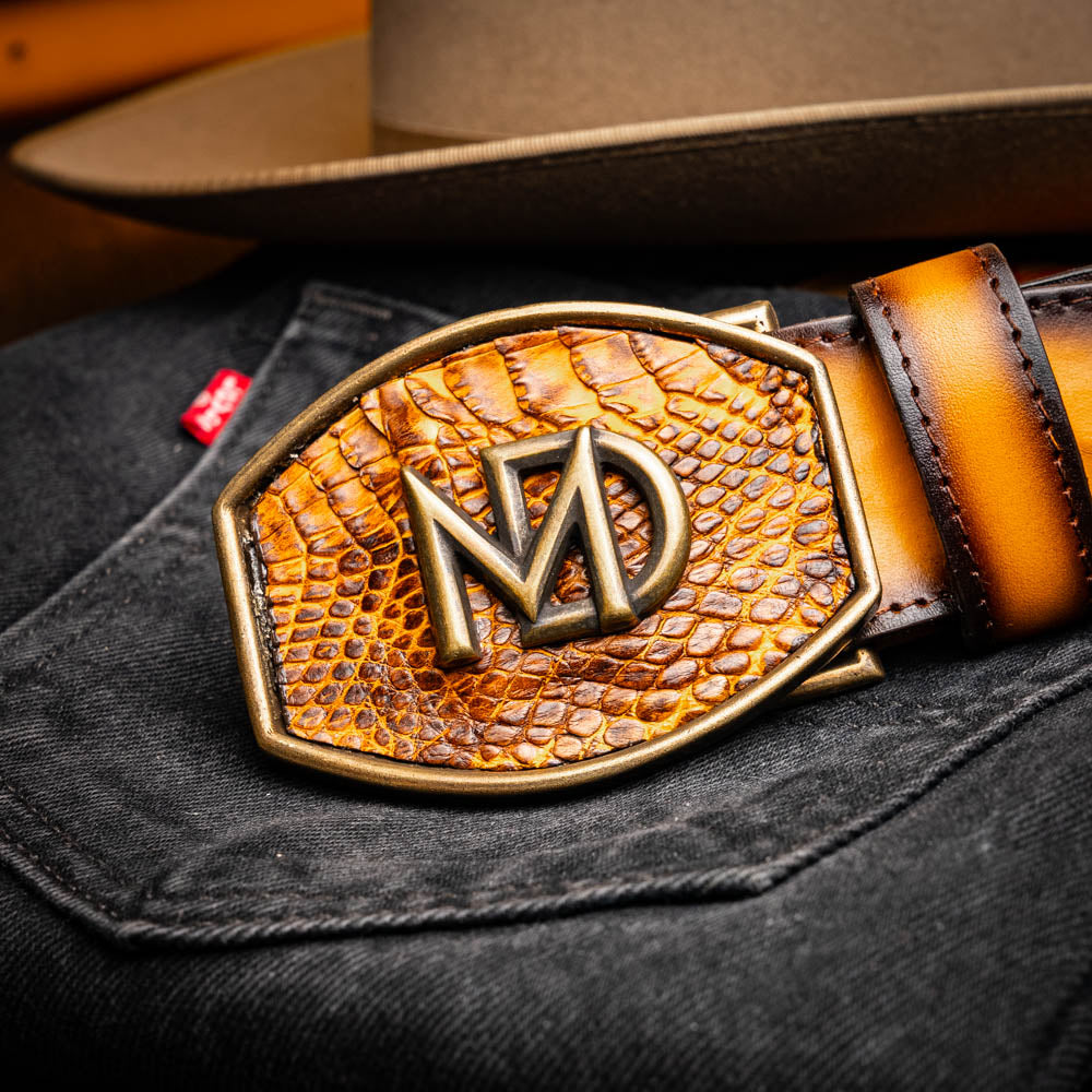The Texas Belt Mustard Brown by Marco Di Milano features a striking gold "MD" logo buckle—an elegant statement accessory embodying modern sophistication.