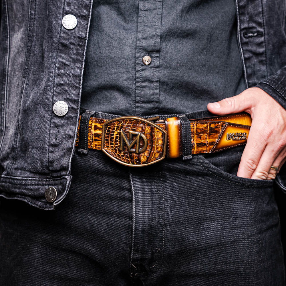 The Texas Belt Mustard Brown by Marco Di Milano features a striking gold "MD" logo buckle—an elegant statement accessory embodying modern sophistication.