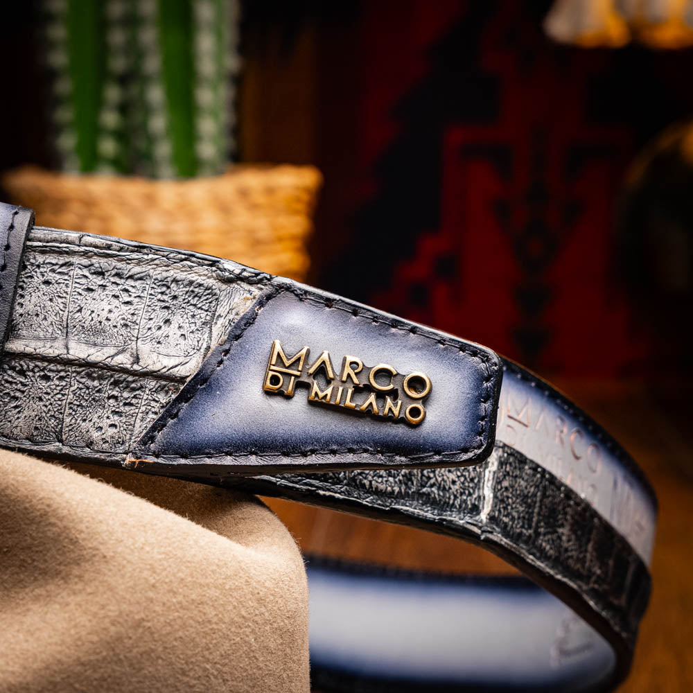The Marco Di Milano Texas Belt Stone Gray features a textured gray finish, a large gold MD logo buckle, and "Marco Di Milano" printed along the strap.