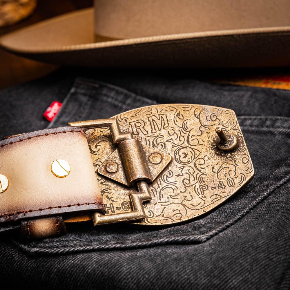 The Texas Belt Stone Orix by Marco Di Milano features embossed tan and brown caiman crocodile leather with a large gold and brown MD logo buckle, shown rolled up against a white background.