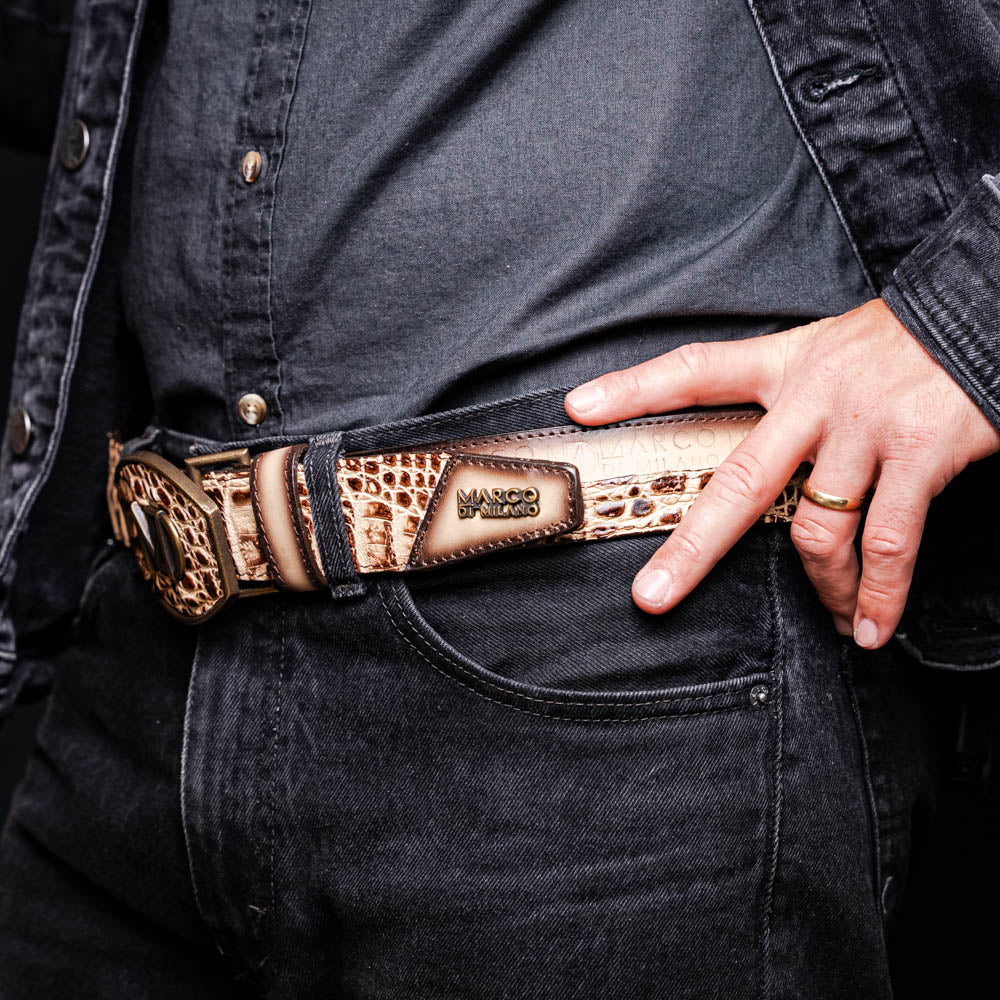 The Texas Belt Stone Orix by Marco Di Milano features embossed tan and brown caiman crocodile leather with a large gold and brown MD logo buckle, shown rolled up against a white background.
