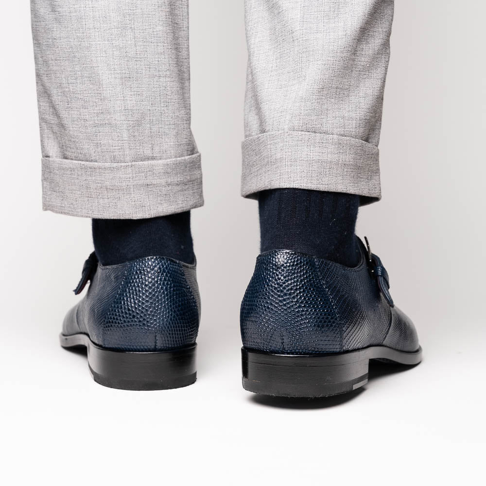 Toluca Navy by Marco Di Milano: a pair of blue textured leather monk strap shoes with a single buckle—one upright, one sole-up showing the brand name—a luxury footwear choice for refined tastes.