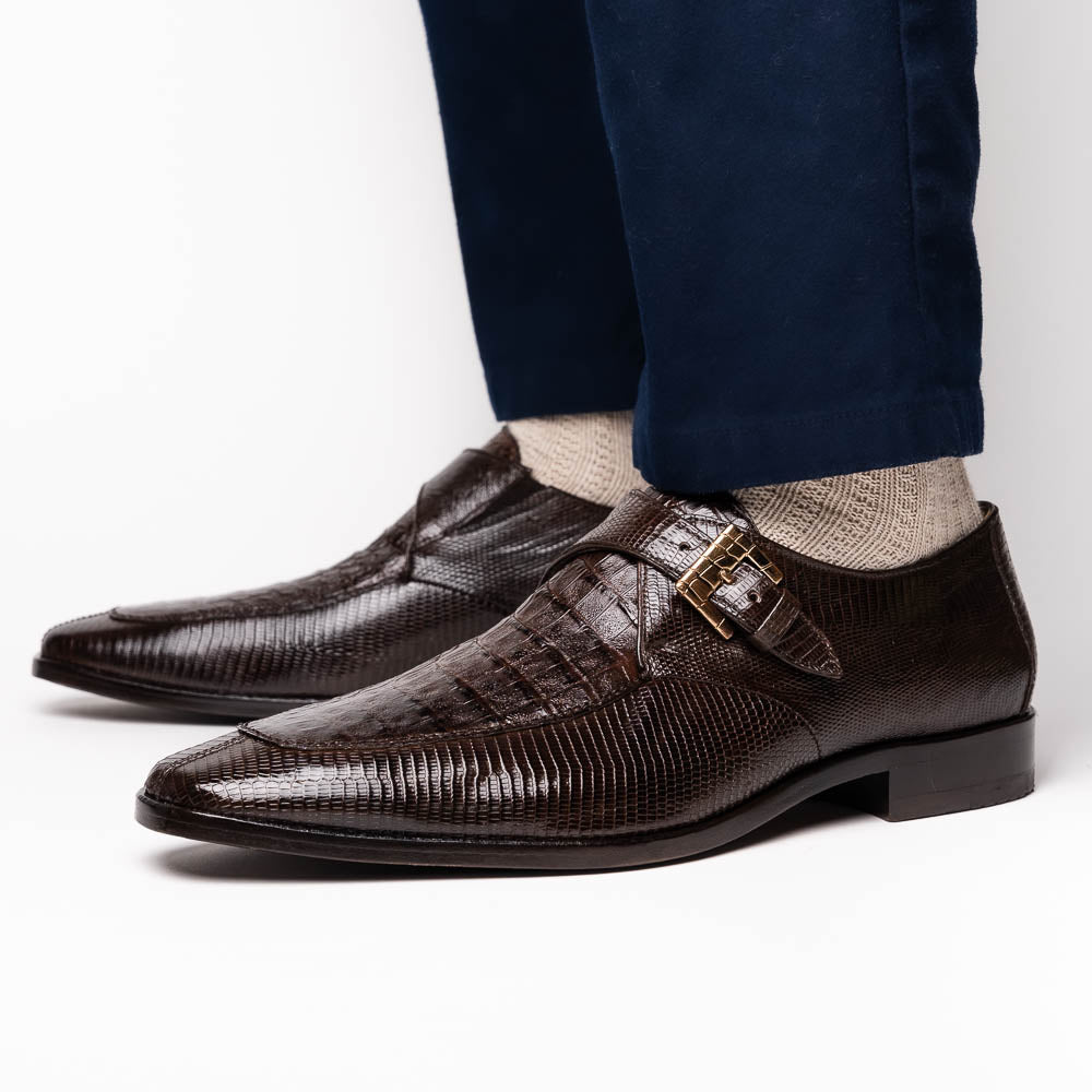 Toluca Brown by Marco Di Milano: luxury men's monk strap shoes in brown crocodile-patterned leather with a side buckle. One shoe stands upright; the other lies on its side to display the sole.