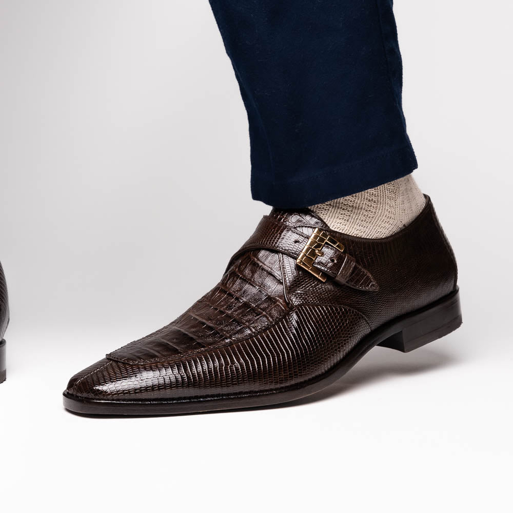 Toluca Brown by Marco Di Milano: luxury men's monk strap shoes in brown crocodile-patterned leather with a side buckle. One shoe stands upright; the other lies on its side to display the sole.