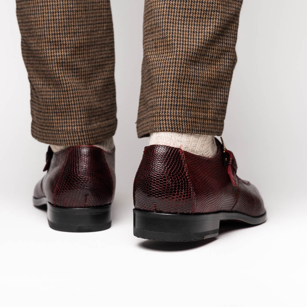 Toluca Wine by Marco Di Milano: Elegant burgundy monk strap shoes with genuine crocodile texture and black soles—one stands upright, the other lies on its side, showcasing luxury craftsmanship.