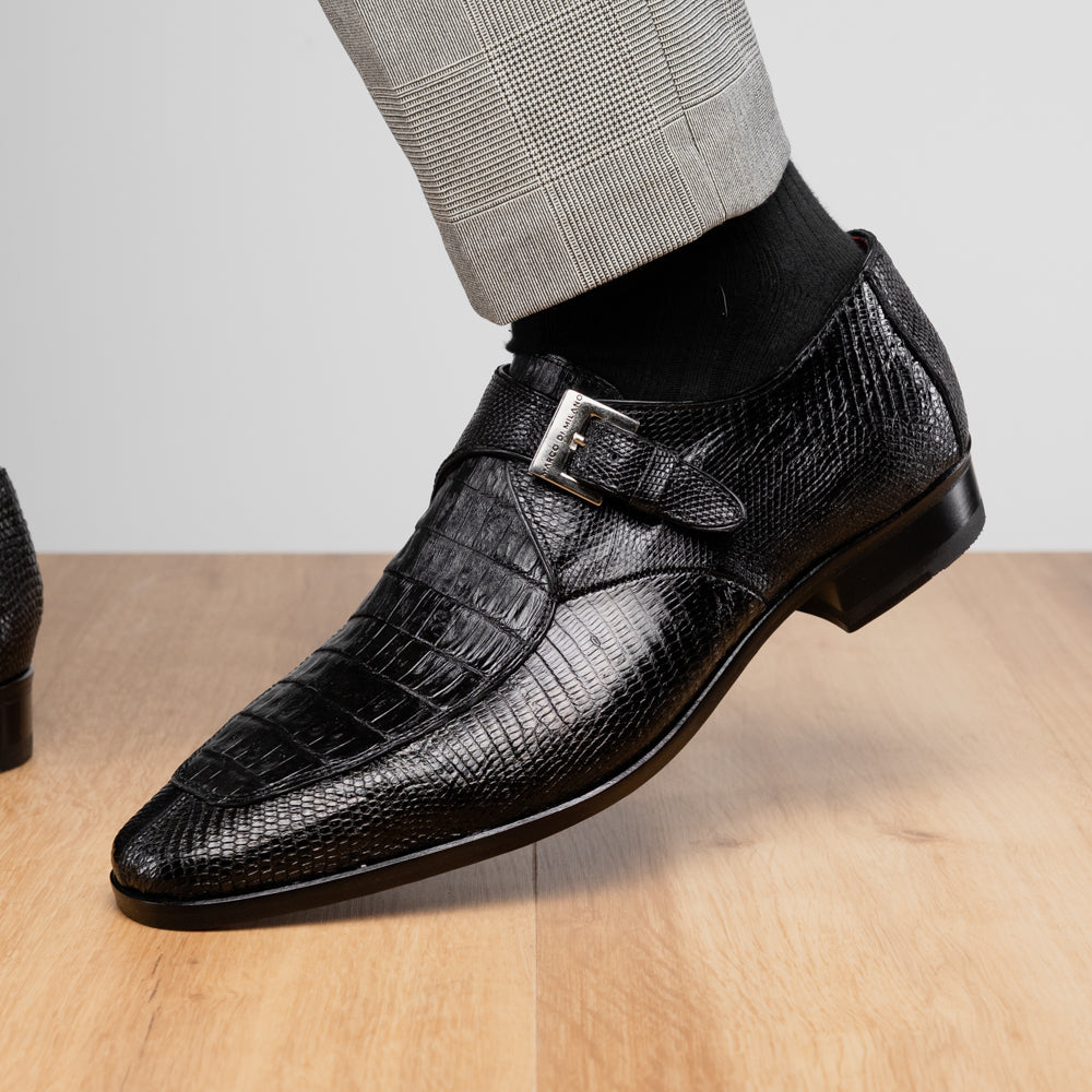 Toluca Black by Marco Di Milano: a black leather dress shoe featuring a crocodile texture and an elegant monk strap side buckle, displayed with one shoe upright and the other revealing its brown leather sole—a refined luxury footwear choice.