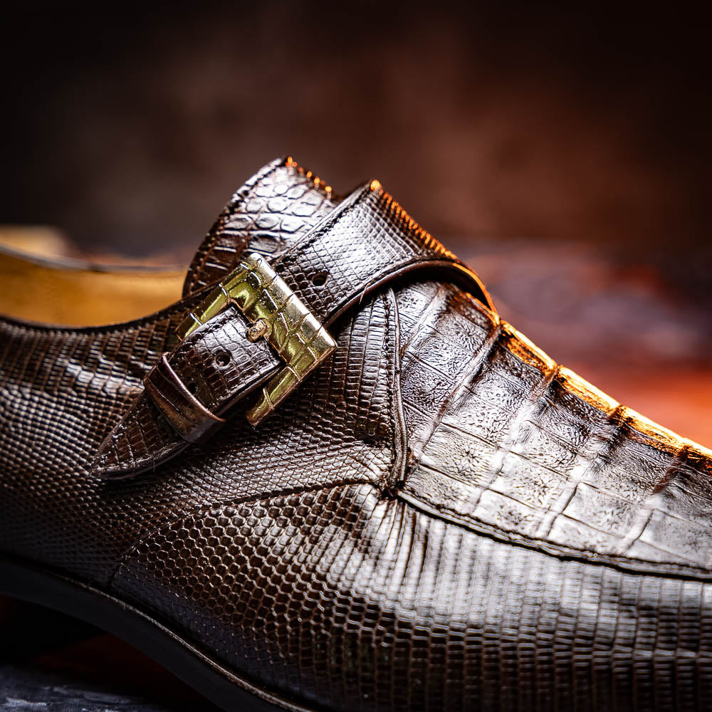 Toluca Brown by Marco Di Milano: luxury men's monk strap shoes in brown crocodile-patterned leather with a side buckle. One shoe stands upright; the other lies on its side to display the sole.
