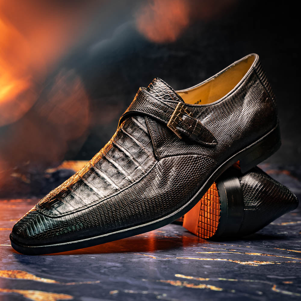 Toluca Brown by Marco Di Milano: luxury men's monk strap shoes in brown crocodile-patterned leather with a side buckle. One shoe stands upright; the other lies on its side to display the sole.