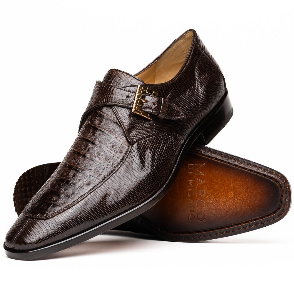 Toluca Brown by Marco Di Milano: luxury men's monk strap shoes in brown crocodile-patterned leather with a side buckle. One shoe stands upright; the other lies on its side to display the sole.
