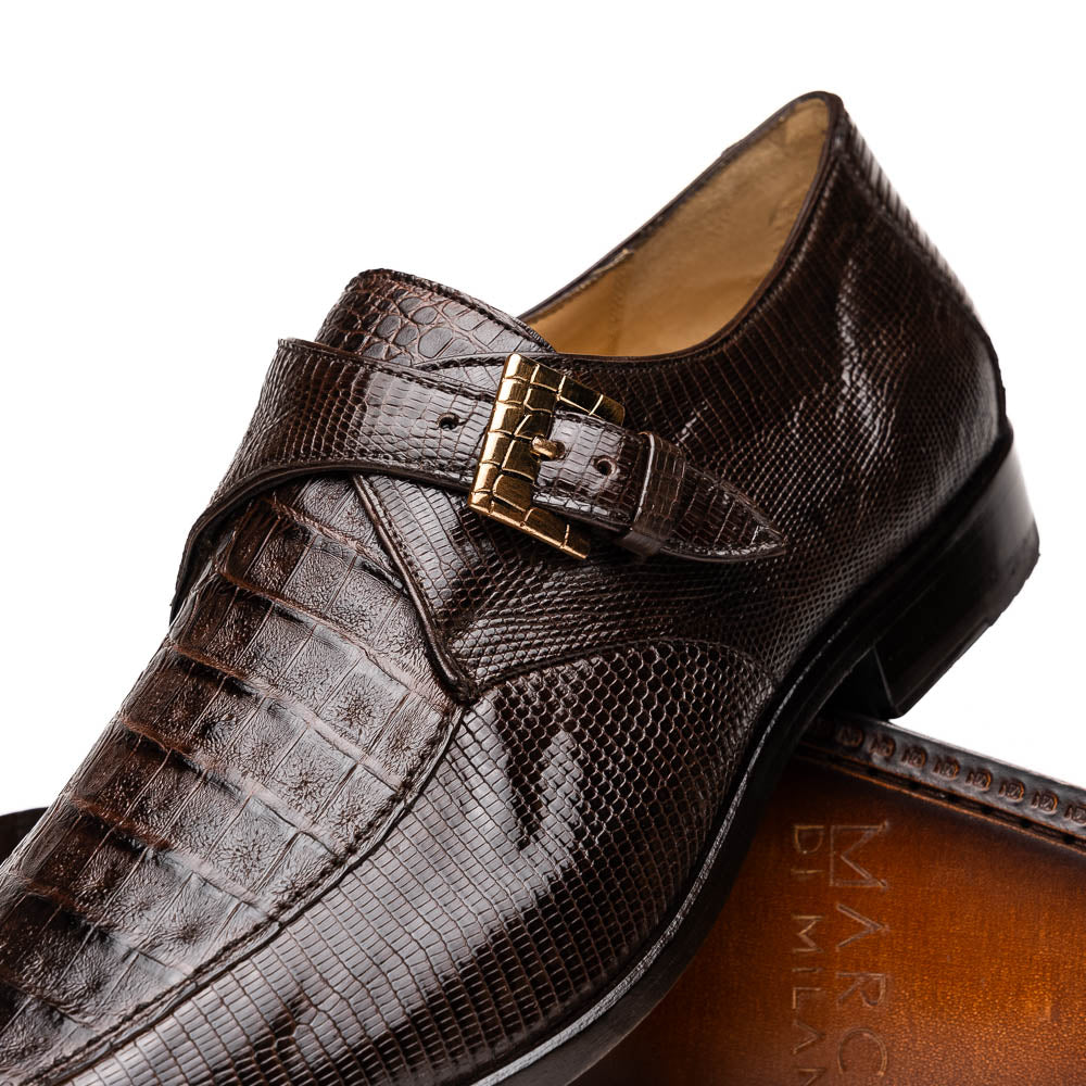 Toluca Brown by Marco Di Milano: luxury men's monk strap shoes in brown crocodile-patterned leather with a side buckle. One shoe stands upright; the other lies on its side to display the sole.