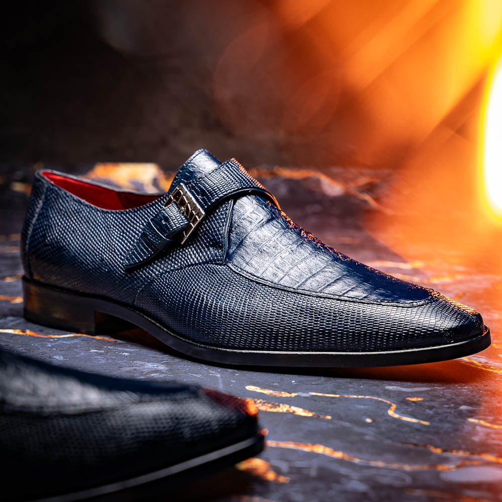 Toluca Navy by Marco Di Milano: a pair of blue textured leather monk strap shoes with a single buckle—one upright, one sole-up showing the brand name—a luxury footwear choice for refined tastes.