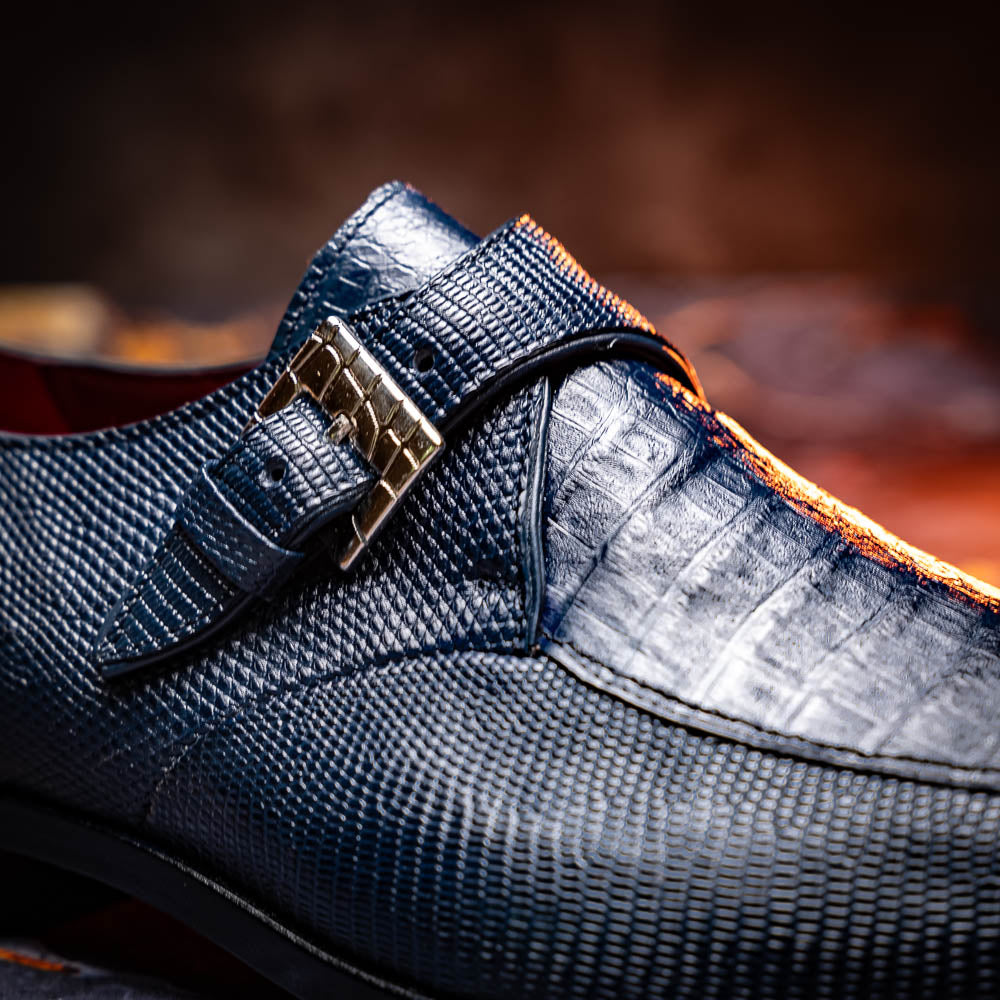 Toluca Navy by Marco Di Milano: a pair of blue textured leather monk strap shoes with a single buckle—one upright, one sole-up showing the brand name—a luxury footwear choice for refined tastes.
