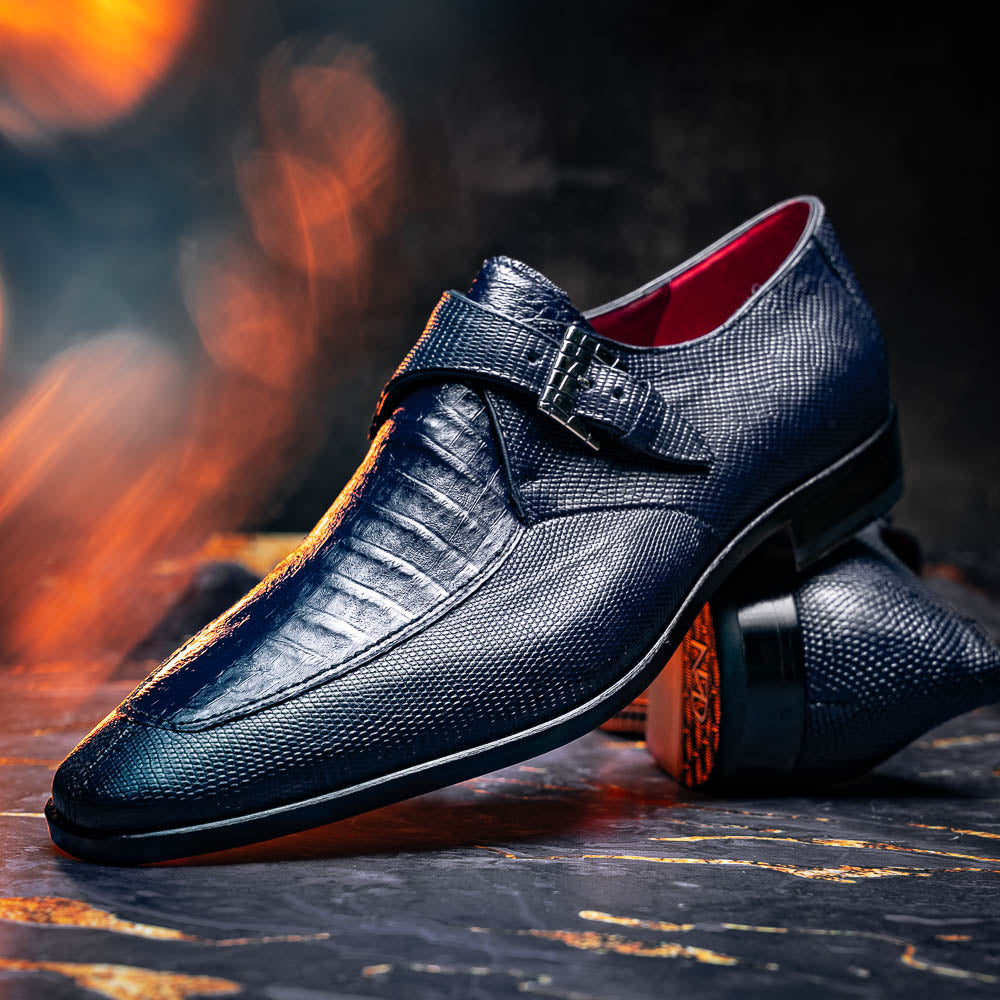 Toluca Navy by Marco Di Milano: a pair of blue textured leather monk strap shoes with a single buckle—one upright, one sole-up showing the brand name—a luxury footwear choice for refined tastes.