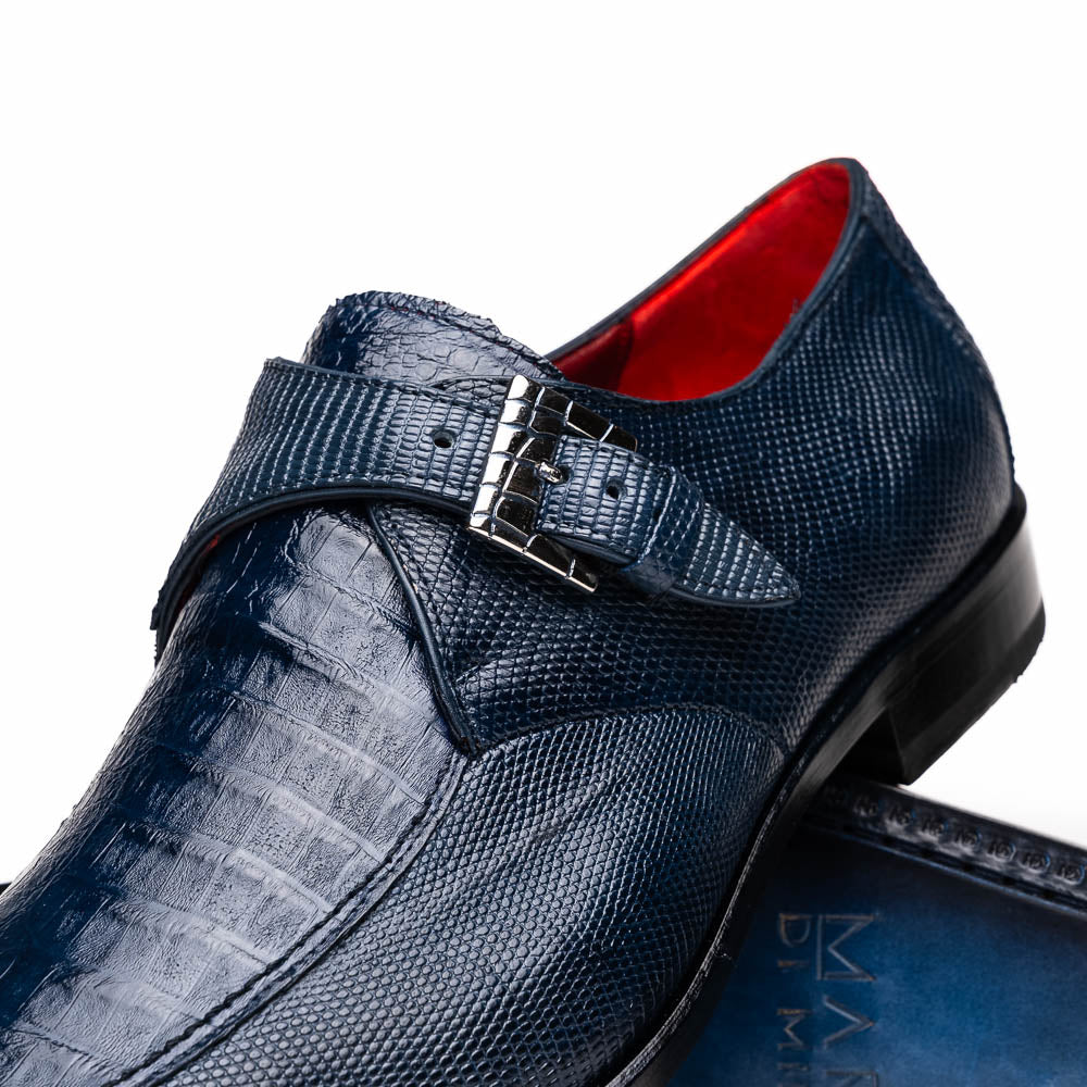 Toluca Navy by Marco Di Milano: a pair of blue textured leather monk strap shoes with a single buckle—one upright, one sole-up showing the brand name—a luxury footwear choice for refined tastes.