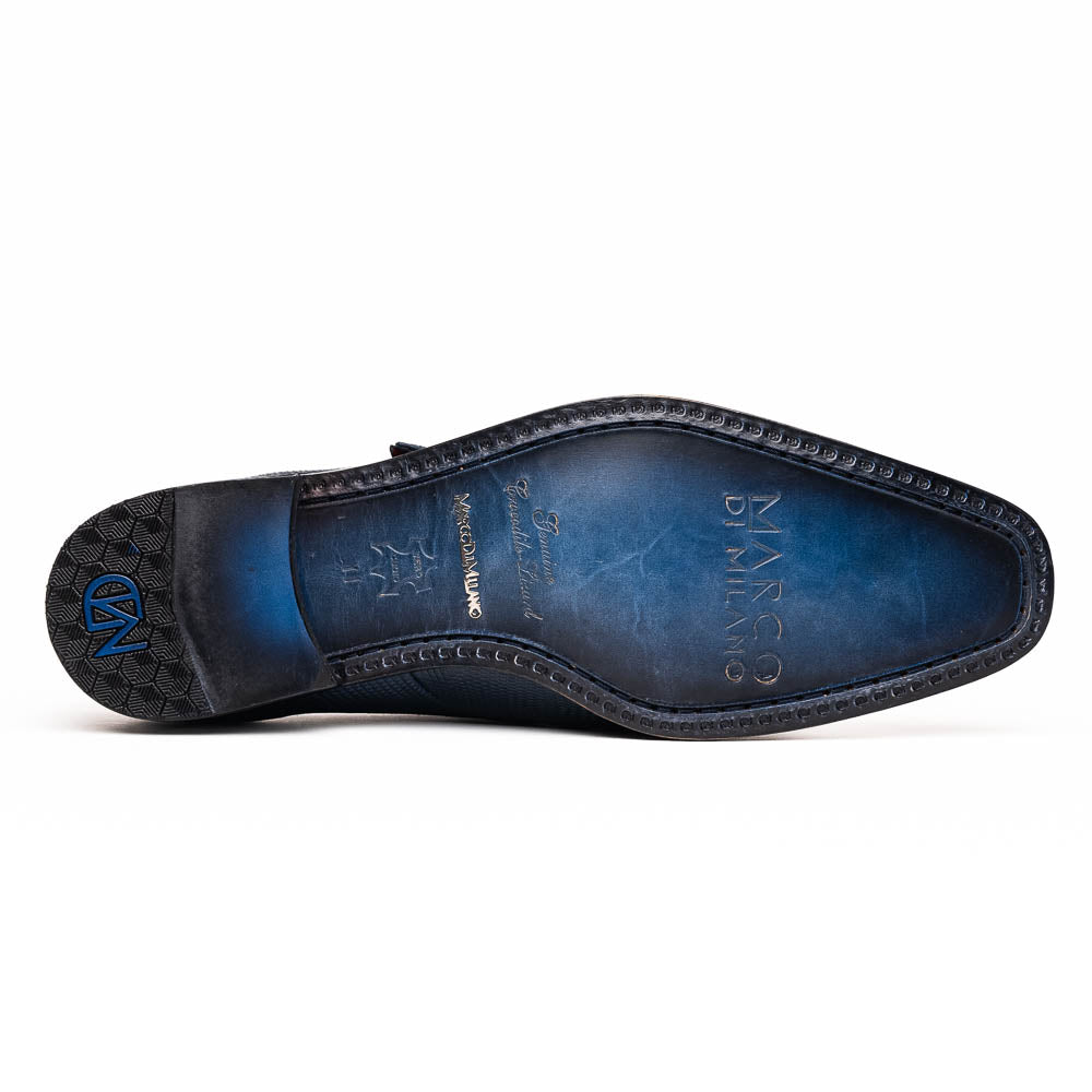 Toluca Navy by Marco Di Milano: a pair of blue textured leather monk strap shoes with a single buckle—one upright, one sole-up showing the brand name—a luxury footwear choice for refined tastes.