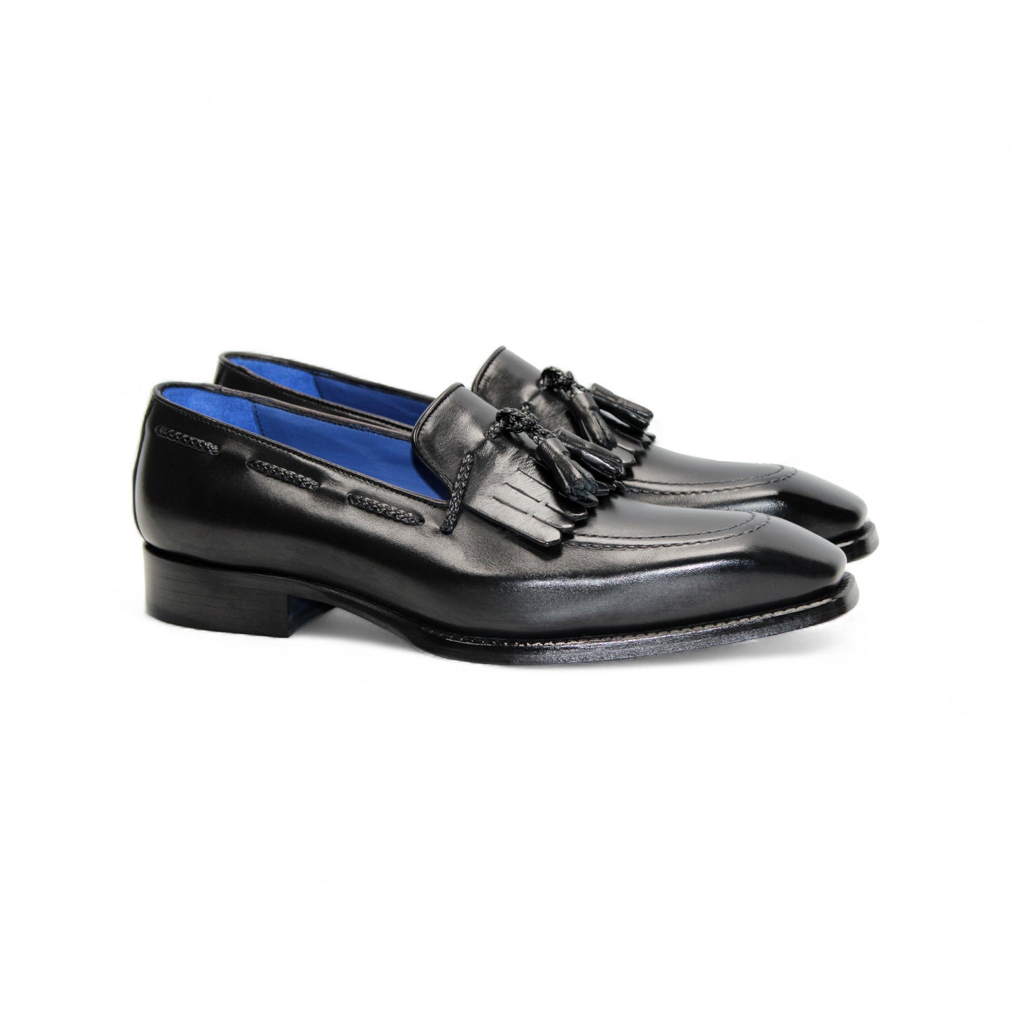 The Emilio Franco Tommaso Black loafer by Emilio Franco features tassel detail, low heel, and stitching accents. Crafted from genuine leather, it's shown from the side on a plain white background.