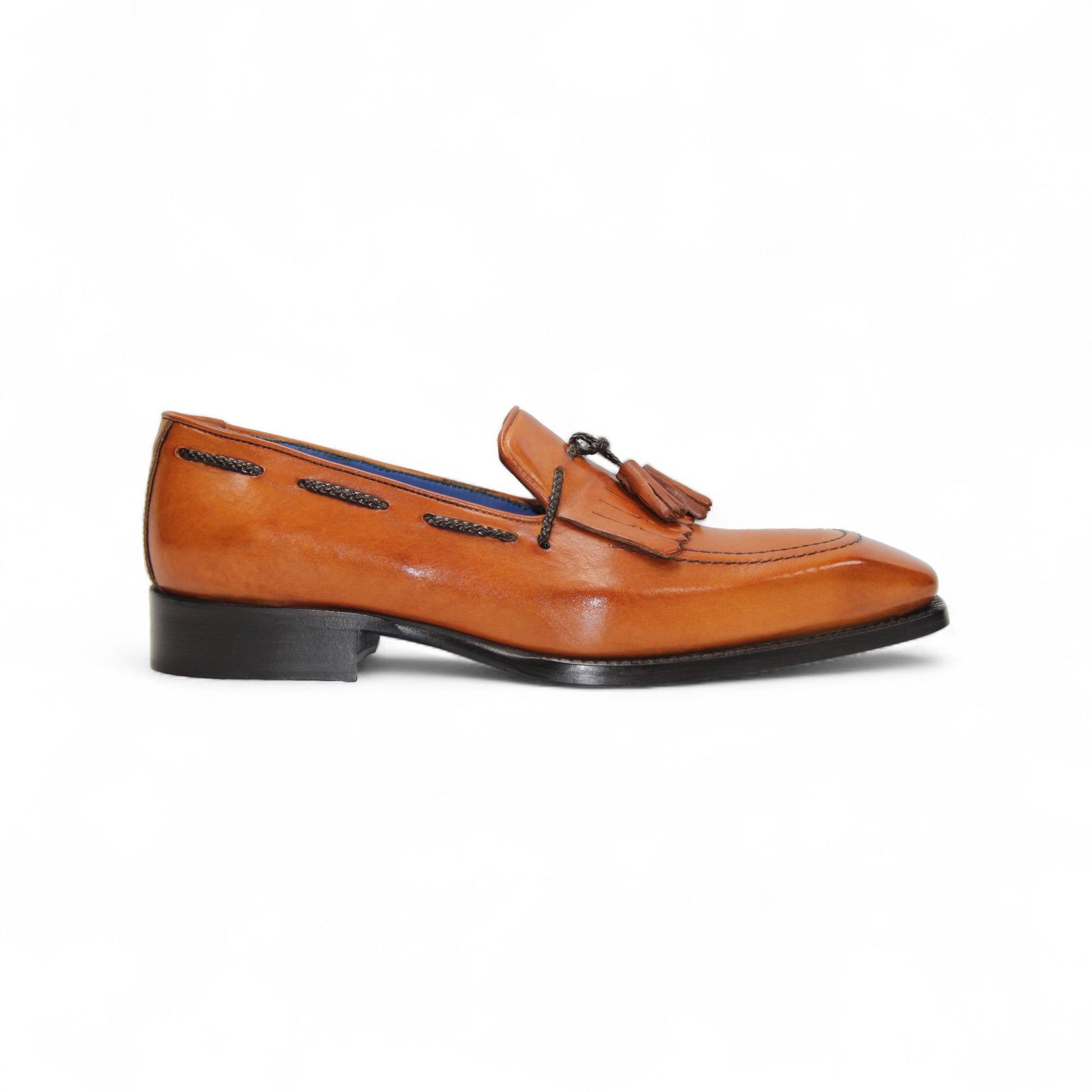 The Emilio Franco Tommaso Gold is a tan leather loafer with a tailored fit, low black heel, tassel detail on the upper, and dark side stitching, shown in side profile against a white background.