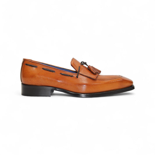 The Emilio Franco Tommaso Gold is a tan leather loafer with a tailored fit, low black heel, tassel detail on the upper, and dark side stitching, shown in side profile against a white background.