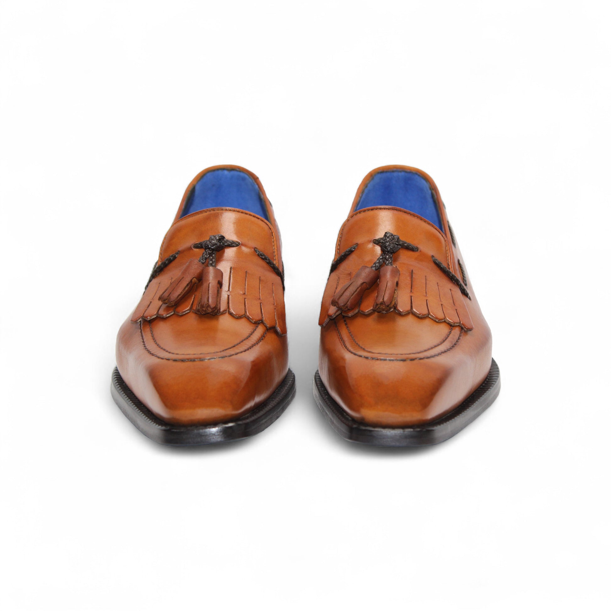 The Emilio Franco Tommaso Gold is a tan leather loafer with a tailored fit, low black heel, tassel detail on the upper, and dark side stitching, shown in side profile against a white background.