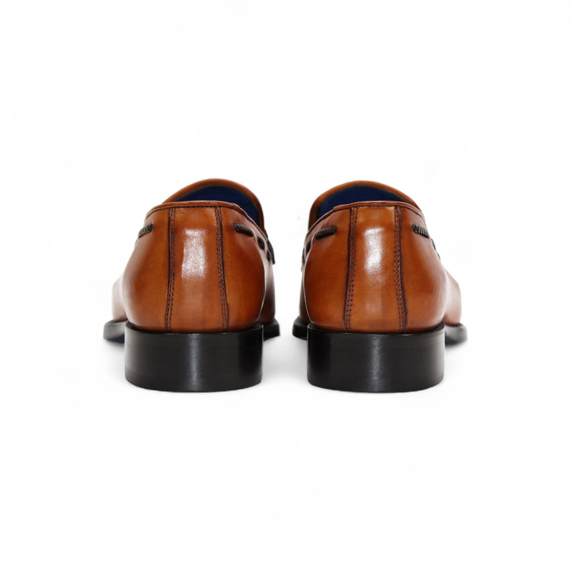 The Emilio Franco Tommaso Gold is a tan leather loafer with a tailored fit, low black heel, tassel detail on the upper, and dark side stitching, shown in side profile against a white background.
