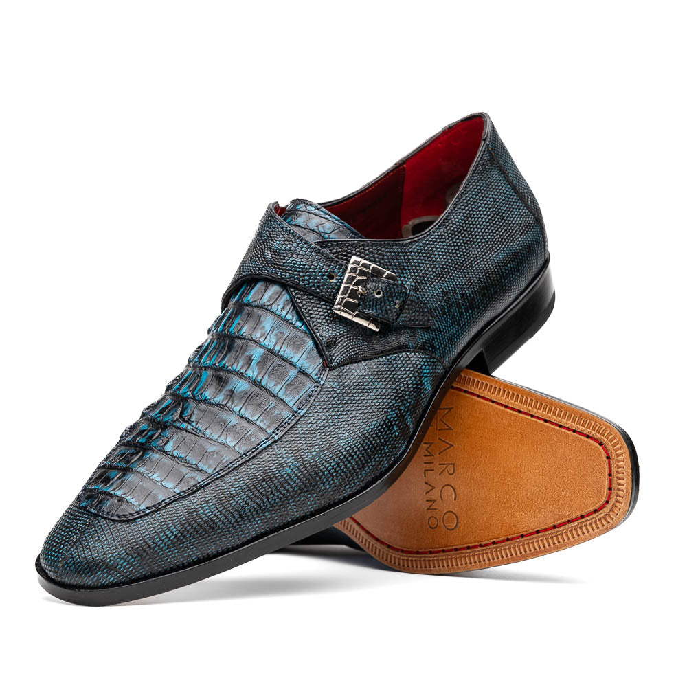A pair of Toluca Rustic Blue exotic leather dress shoes by Marco Di Milano features a buckle detail, with one shoe on its side showing the tan leather sole and “MARCO DI MILANO” branding.