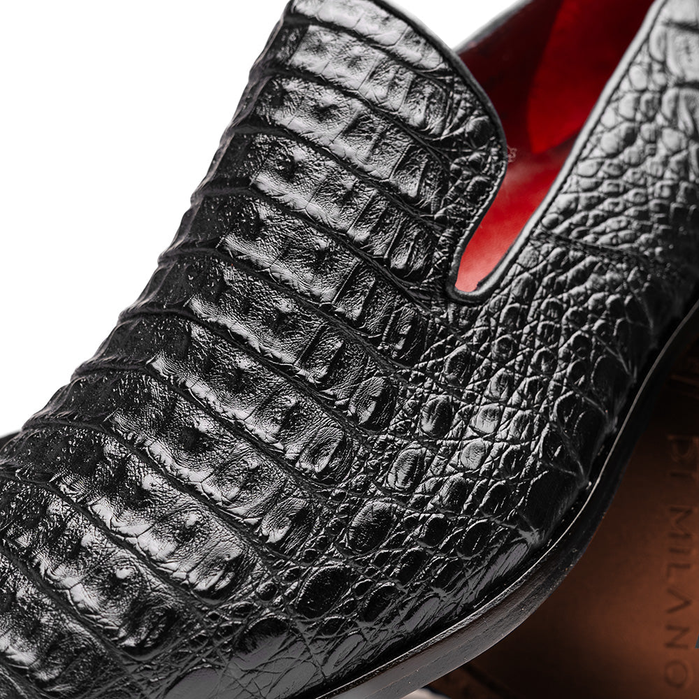 A pair of Marco Di Milano Trento Black loafers crafted from genuine caiman crocodile-pattern leather, showcasing a striking black exterior, red interior lining, and brown soles—one positioned upright and the other on its side. These luxury shoes feature exquisite hand-painted finishes for a truly sophisticated touch.