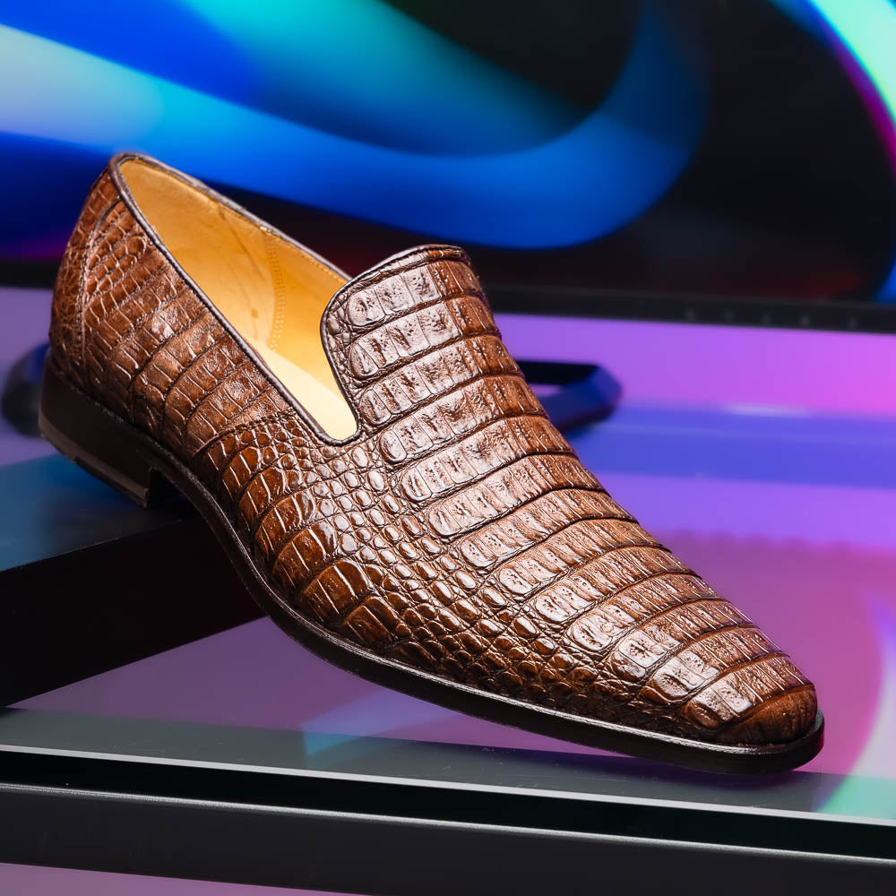 The Marco Di Milano Trento Brown shoes, crafted from genuine caiman crocodile leather, are shown with one upright and one on its side to reveal the sole, highlighting their hand-painted luxury finish.