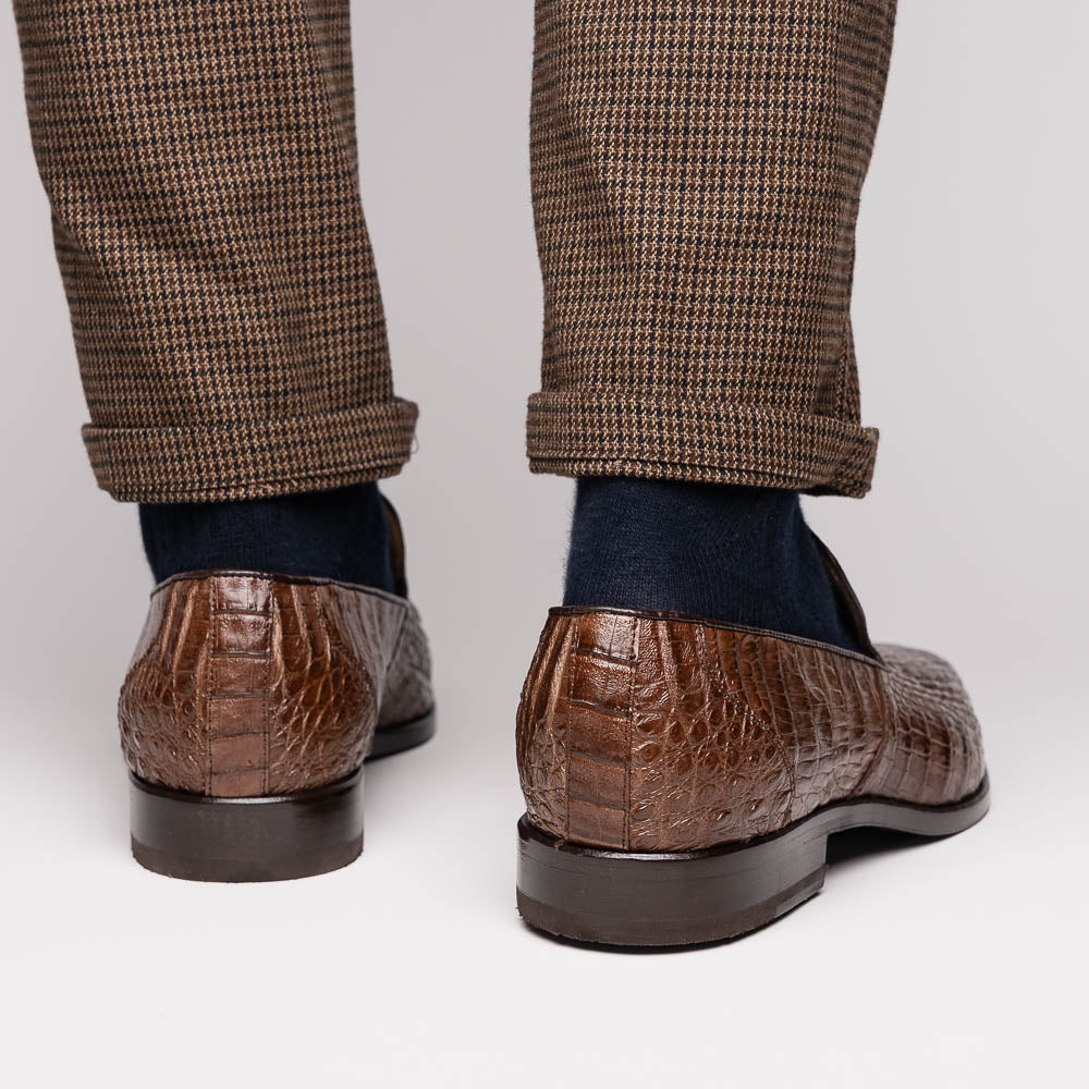 The Marco Di Milano Trento Brown shoes, crafted from genuine caiman crocodile leather, are shown with one upright and one on its side to reveal the sole, highlighting their hand-painted luxury finish.