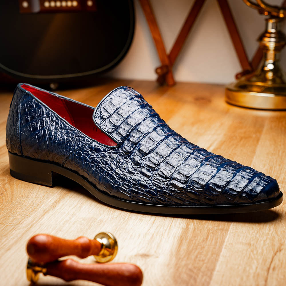 The Trento Navy by Marco Di Milano are dark blue genuine caiman leather loafers featuring hand-painted finishes, red lining, and "Marco Di Milano" branding on the sole.
