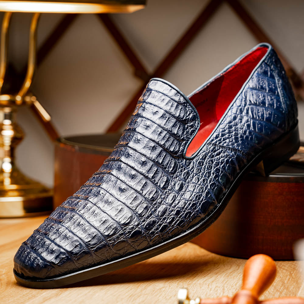 The Trento Navy by Marco Di Milano are dark blue genuine caiman leather loafers featuring hand-painted finishes, red lining, and "Marco Di Milano" branding on the sole.