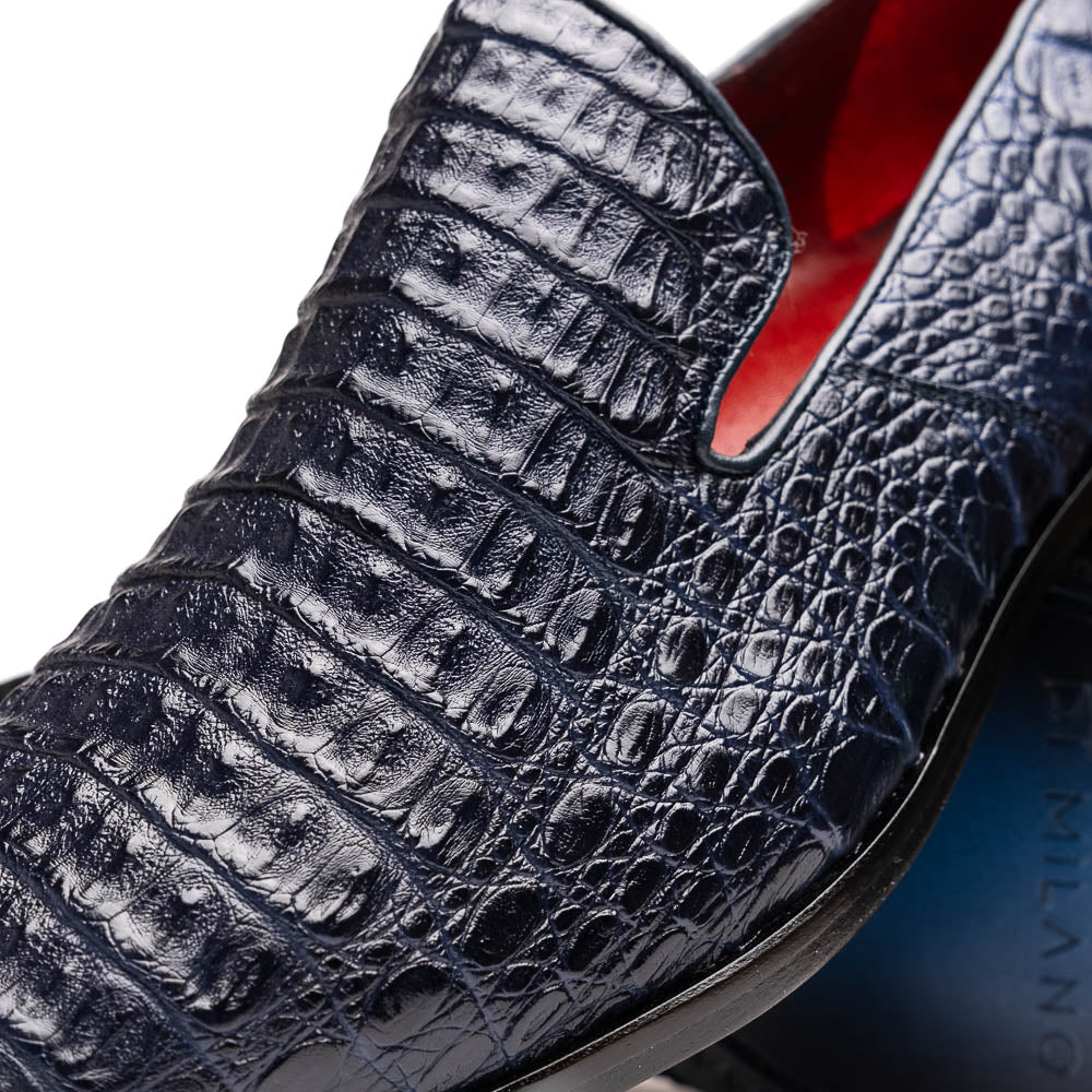 The Trento Navy by Marco Di Milano are dark blue genuine caiman leather loafers featuring hand-painted finishes, red lining, and "Marco Di Milano" branding on the sole.