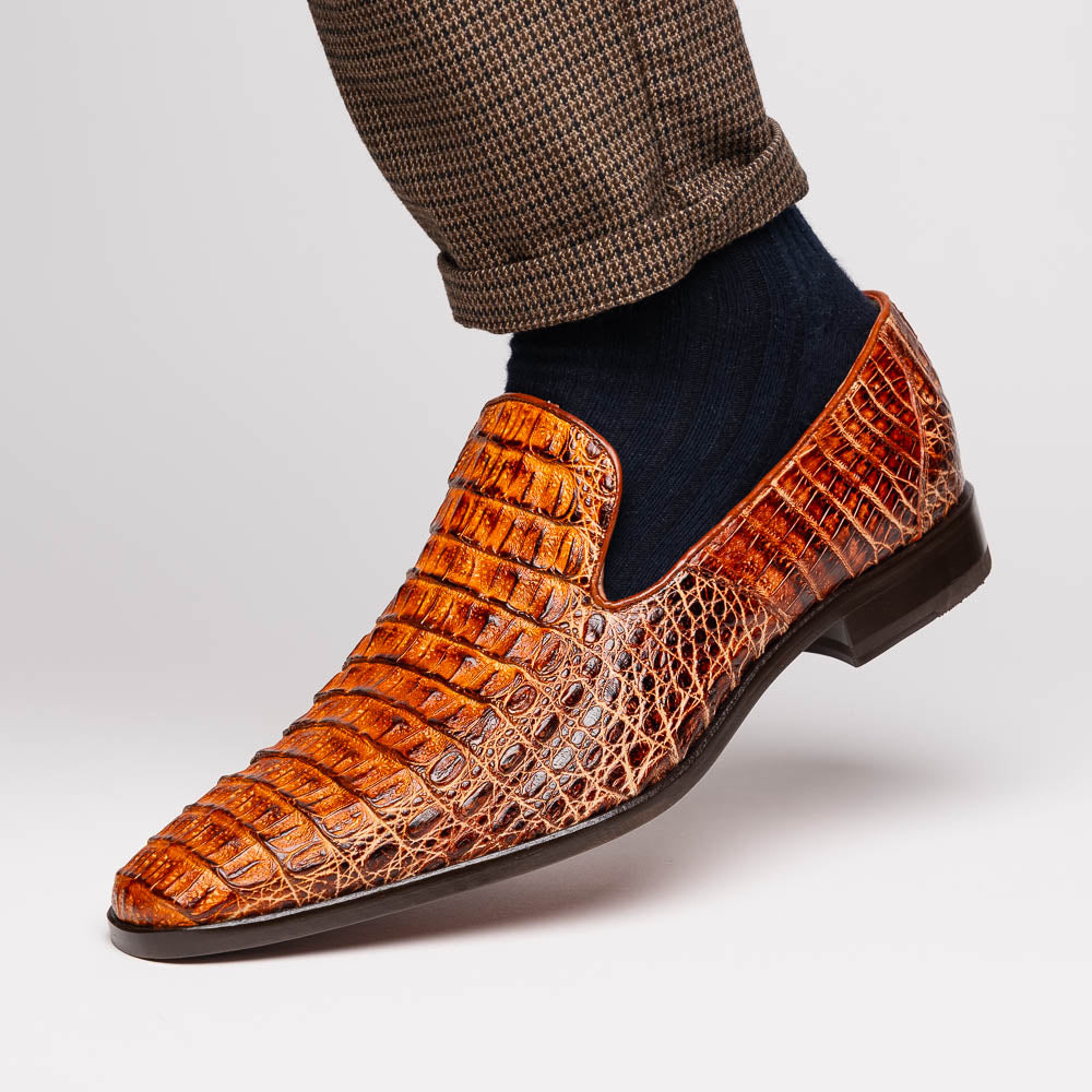 The Marco Di Milano Trento Rustic Cognac shoes, crafted from genuine caiman crocodile leather with a hand-painted finish, are displayed—one upright and one showing the sole—to highlight this luxurious footwear’s exquisite design.
