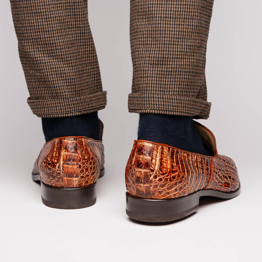 The Marco Di Milano Trento Rustic Cognac shoes, crafted from genuine caiman crocodile leather with a hand-painted finish, are displayed—one upright and one showing the sole—to highlight this luxurious footwear’s exquisite design.