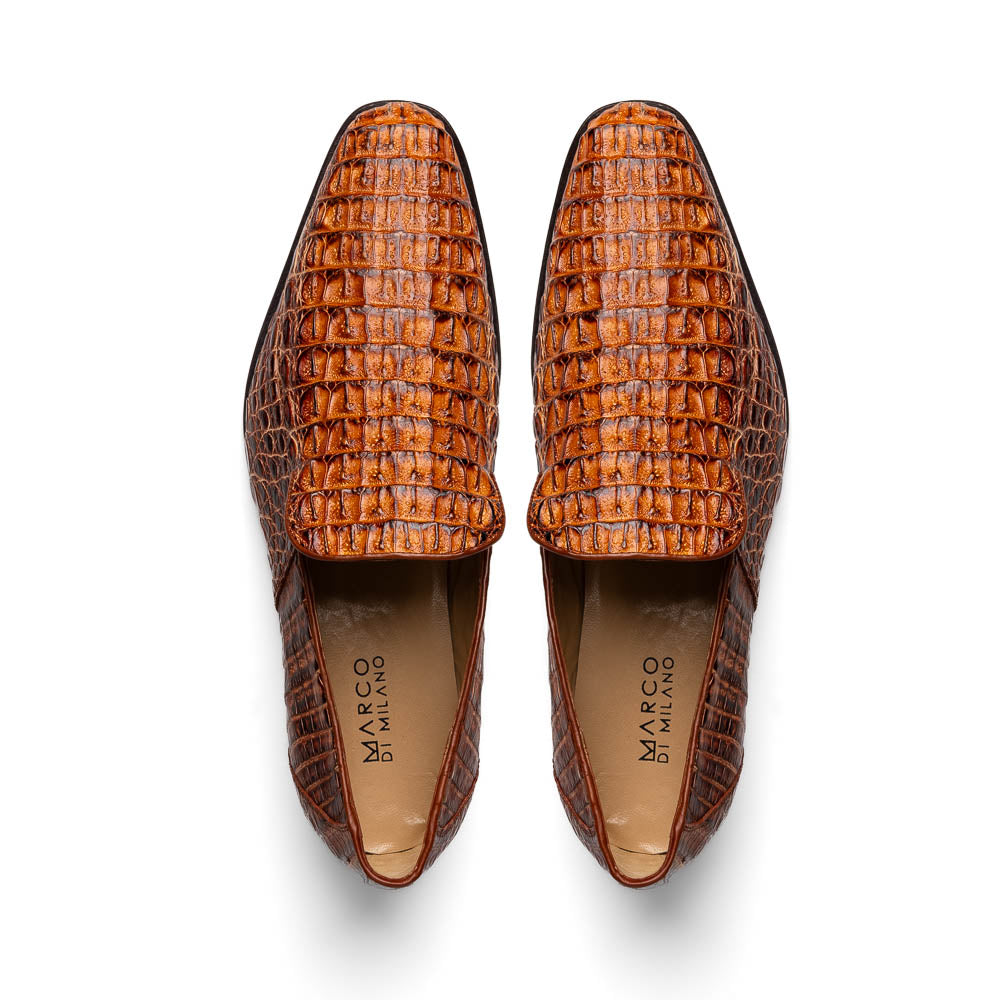 The Marco Di Milano Trento Rustic Cognac shoes, crafted from genuine caiman crocodile leather with a hand-painted finish, are displayed—one upright and one showing the sole—to highlight this luxurious footwear’s exquisite design.