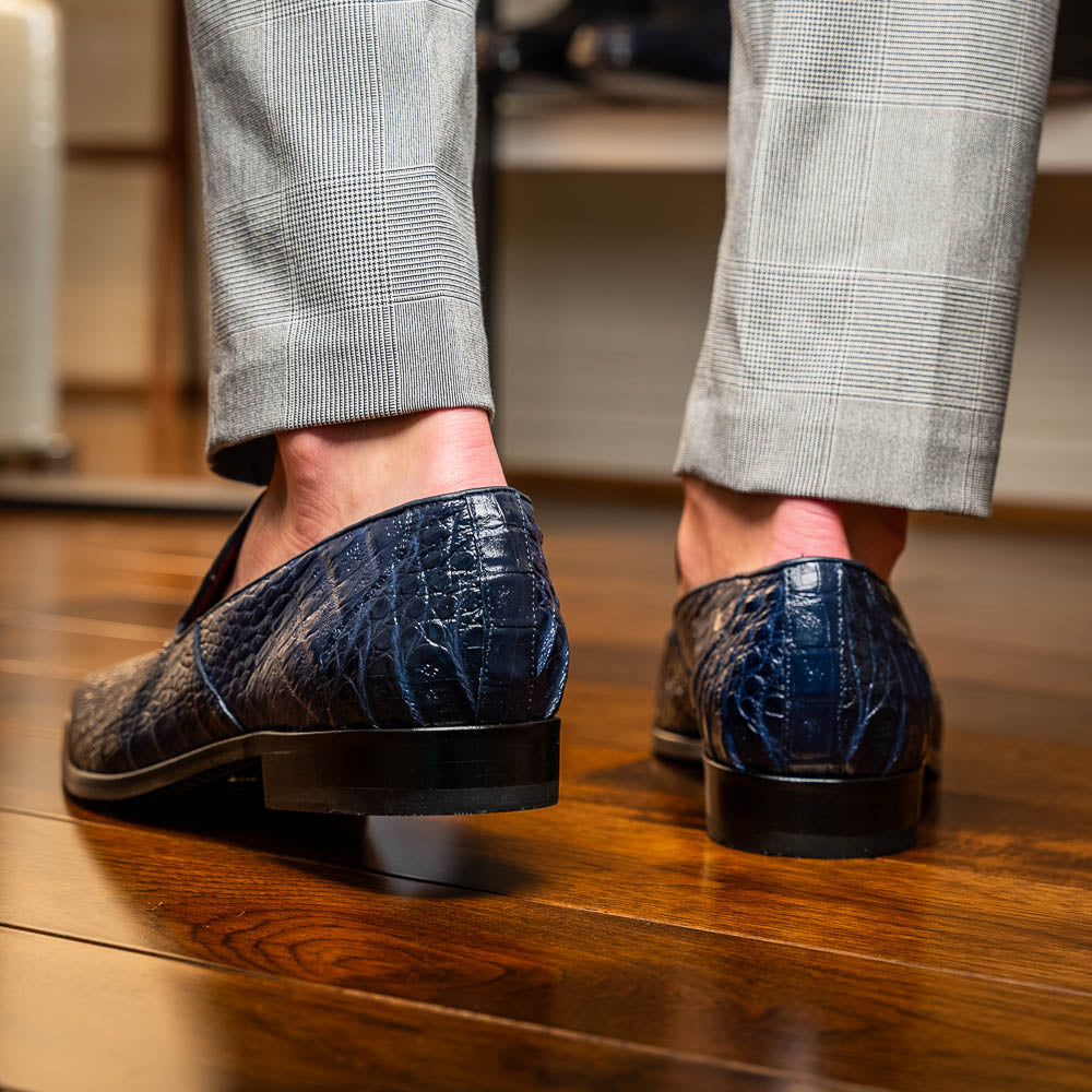 The Trento Navy by Marco Di Milano are dark blue genuine caiman leather loafers featuring hand-painted finishes, red lining, and "Marco Di Milano" branding on the sole.