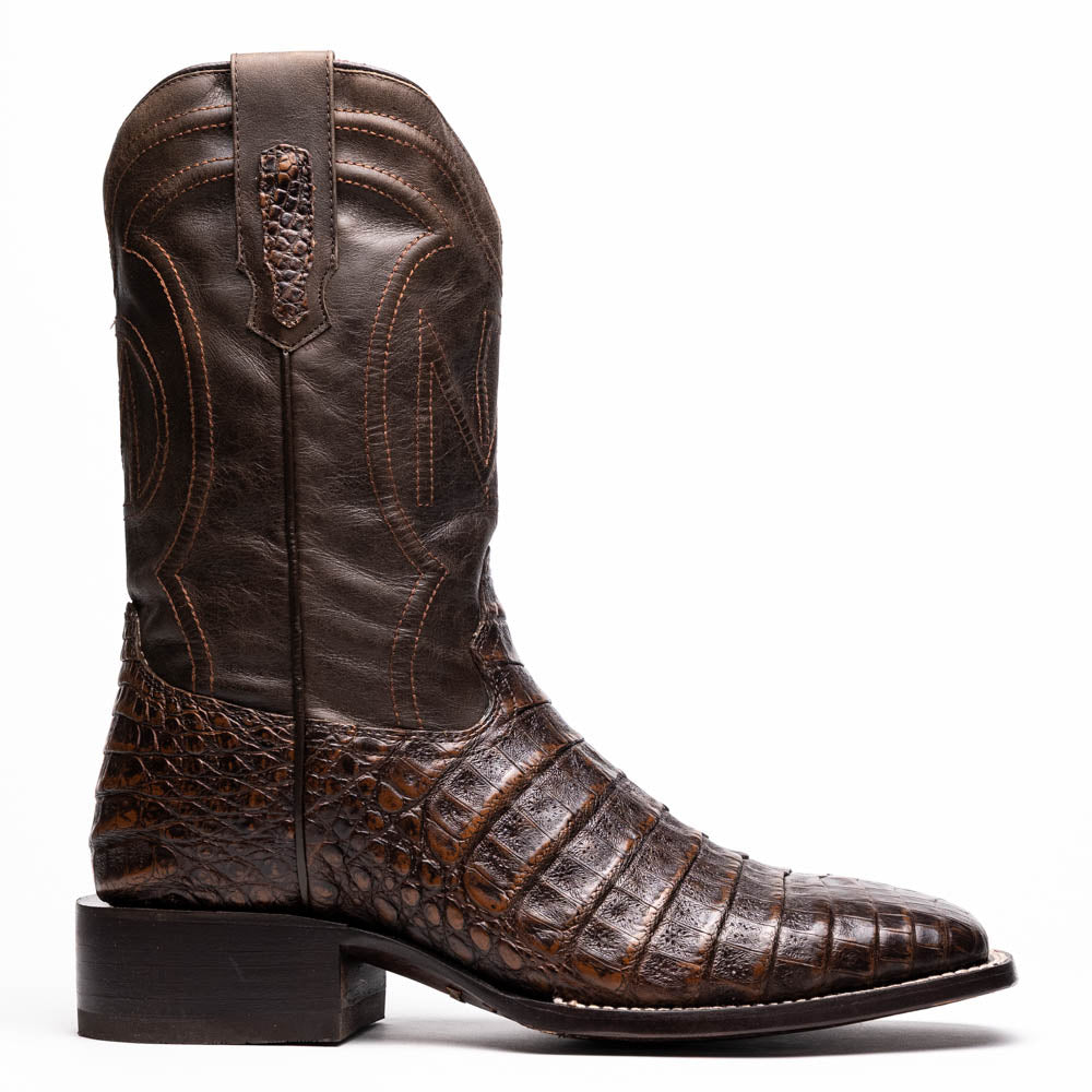A pair of Marco Di Milano Tucson Aged Brown cowboy boots with textured caiman belly leather—one boot stands upright while the other displays its sole, branded "Marco di Milano.