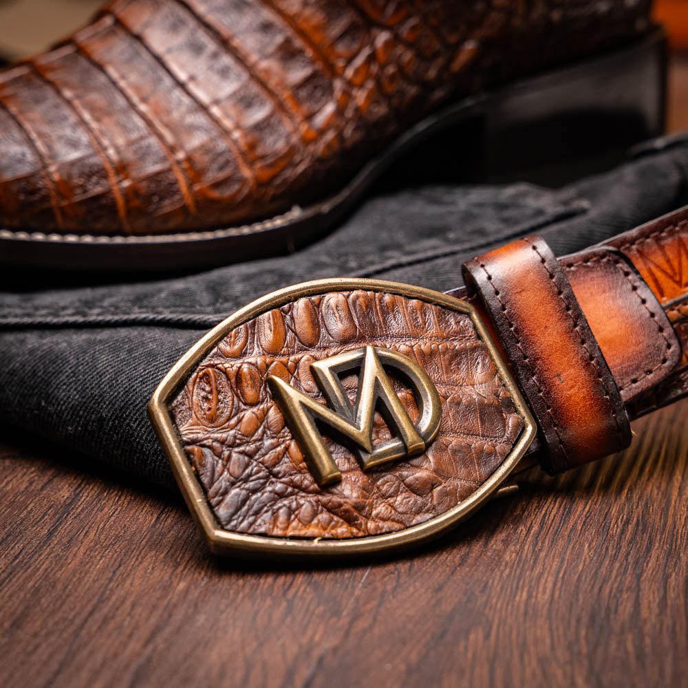 A pair of Tucson Aged Maple brown genuine leather western boots by Marco Di Milano with a textured finish; one boot upright, the other displaying the sole with "Marco Di Milano" branding.